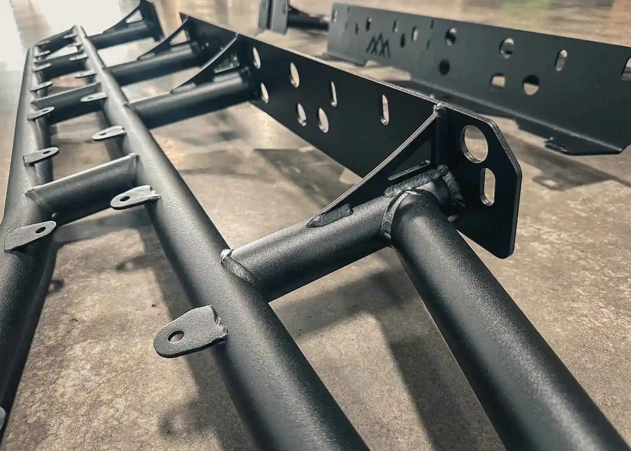 Close up image of the heavy-duty gusseted frame mounts of the Backwoods Adventure Mods 2005-2023 2nd and 3rd Gen Toyota Tacoma bolt-on Rock Sliders