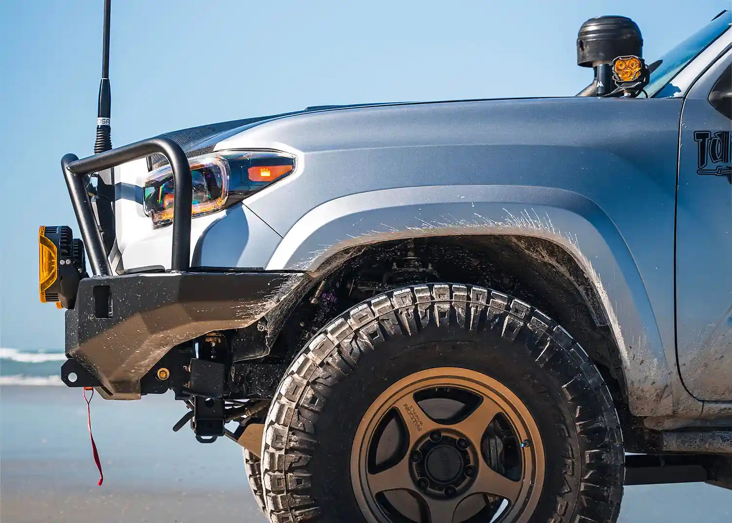 Side Profile of the Hi-Lite Overland 2016-2023 Tacoma Front Bumper with Bull Bar installed on a light blue 3rd Gen Tacoma