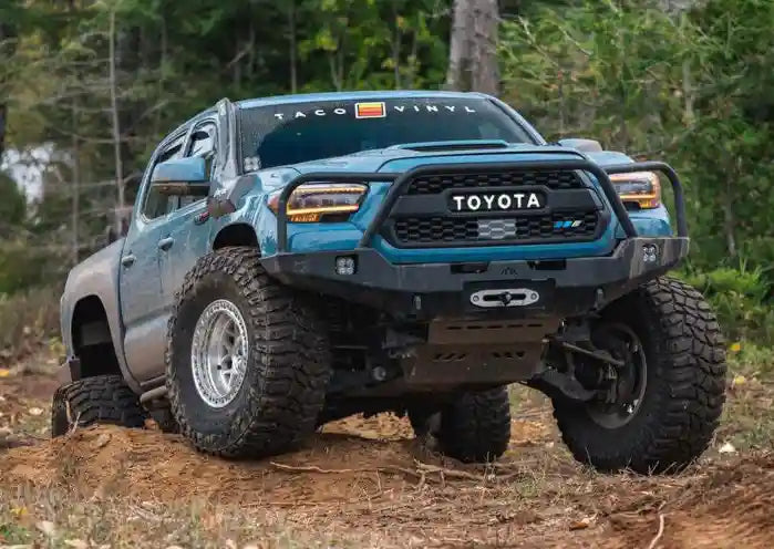 Blue 3rd gen tacoma with Backwoods Adventure Mods Hi-Lite Overland Tacoma Front Bumper with Bull Bar driving off road