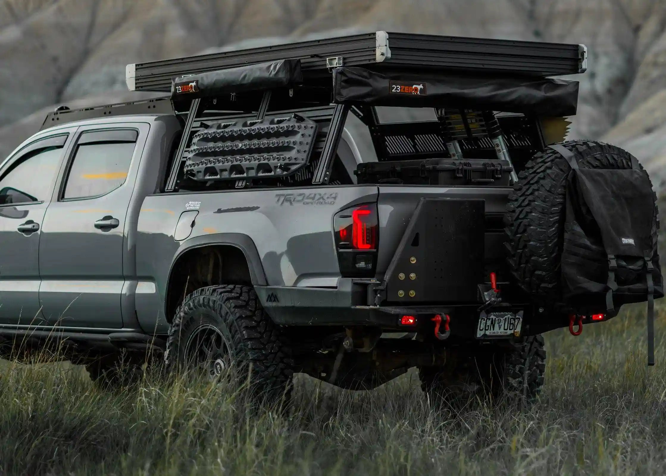 Backwoods Adventure Mods 2016-2023 Toyota Tacoma Hi-Lite High Clearance Dual Swing Out Rear Bumper installed on a gray 3rd Gen Tacoma overland truck build