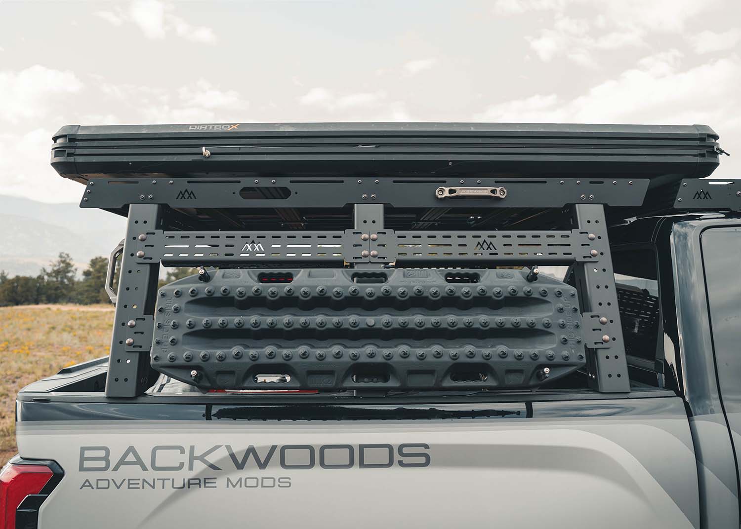 Image showing the side of the Backwoods Adventure Mods Full Height 3rd Gen Toyota Tundra Truck Bed Rack installed with a roof top tent mounted and off road recovery gear mounted