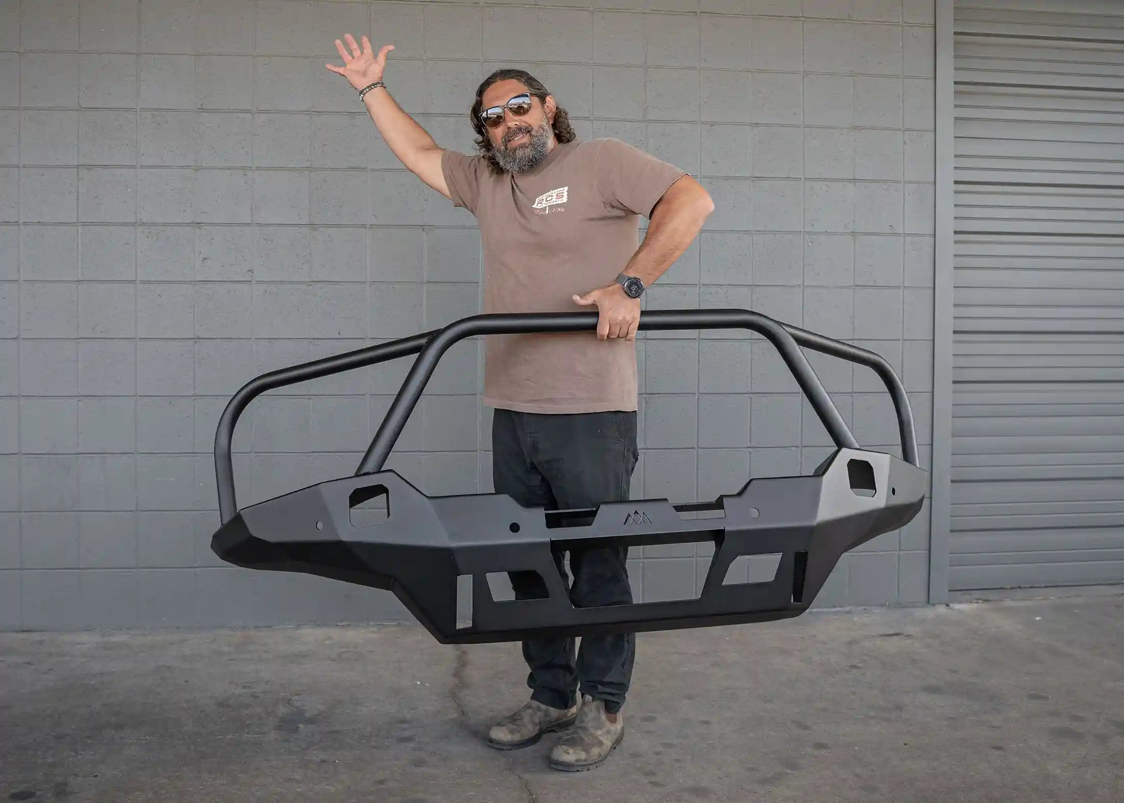 Man lifting the Backwoods Adventure Mods Toyota Tacoma 4th Gen (2024) Hi-Lite Front Bull Bar Bumper with one hand