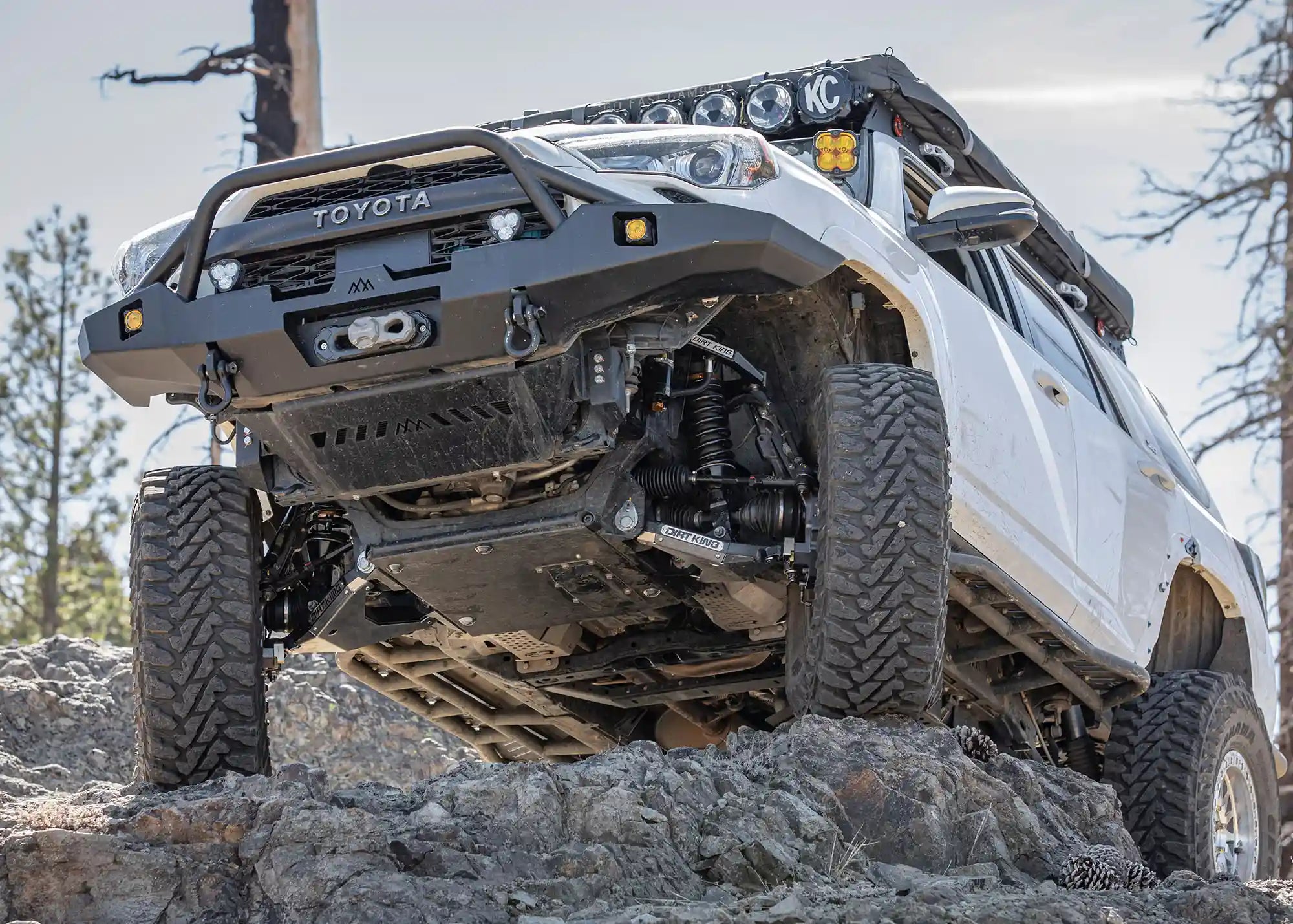 White 5th Gen Toyota 4runner equipped with a Backwoods Adventure Mods Hi-Lite Overland Front Bumper with Prerunner Bull Bar rock crawling off road