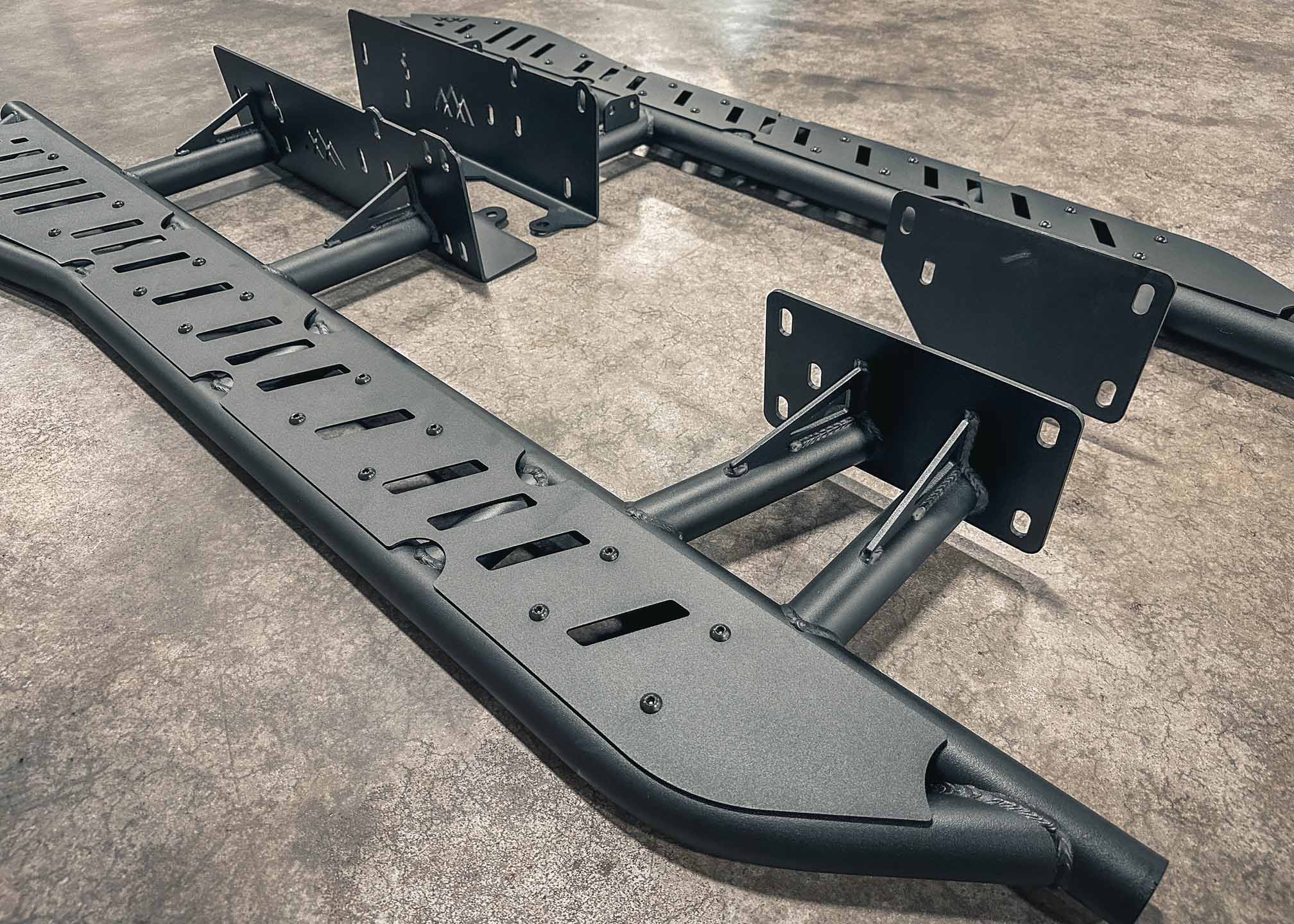 Close up image of the heavy-duty gusseted frame mounts and bolt-on top plates of the Backwoods Adventure Mods 2010-2024 5th Gen Toyota 4Runner Rock Sliders