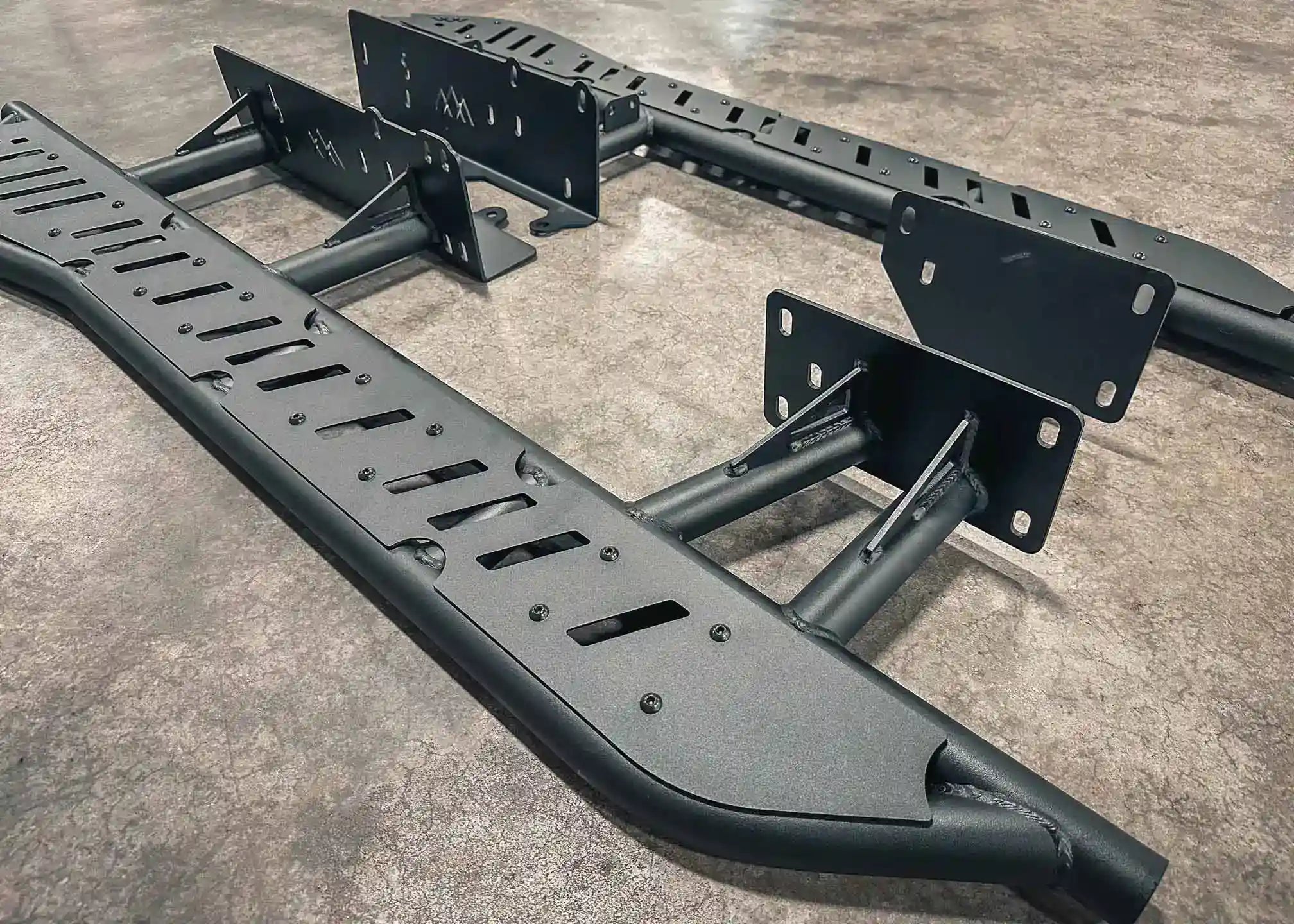 Close up image of the heavy-duty gusseted frame mounts and bolt-on top plates of the Backwoods Adventure Mods 2010-2024 5th Gen Toyota 4Runner Rock Sliders