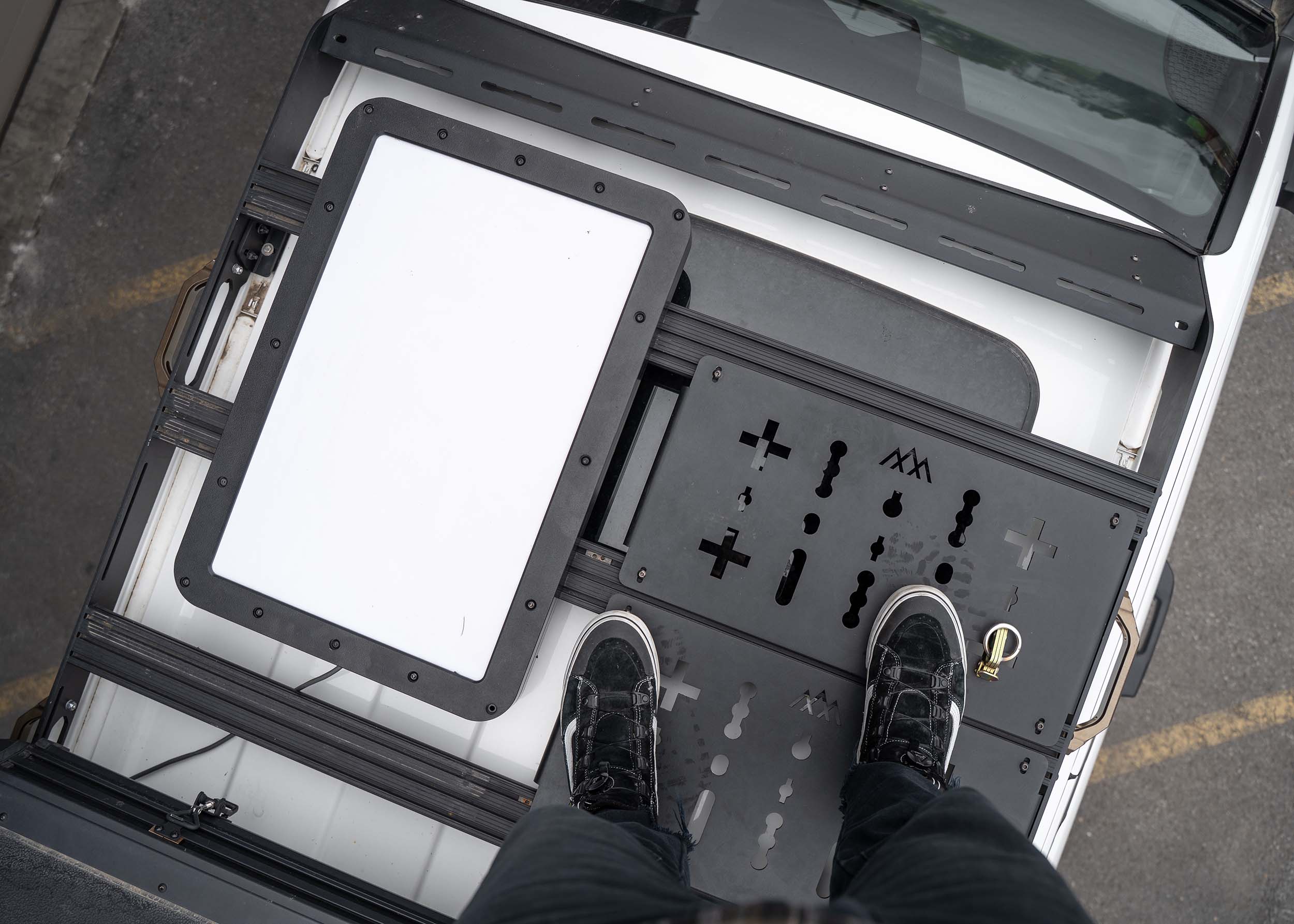 Man standing on top of the DRIFTR 2024+ 4th Gen Toyota Tacoma Roof Rack with optional deck panels installed