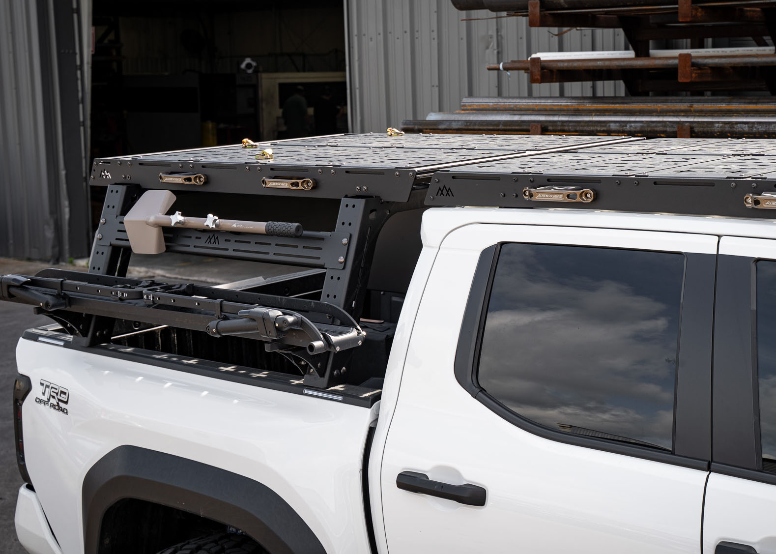 Upper cargo storage deck of the Backwoods Adventure Mods Truck Bed Rack and Roof Rack System Expert Bundle installed on a Toyota Tacoma with other rack accessories mounted to the sides