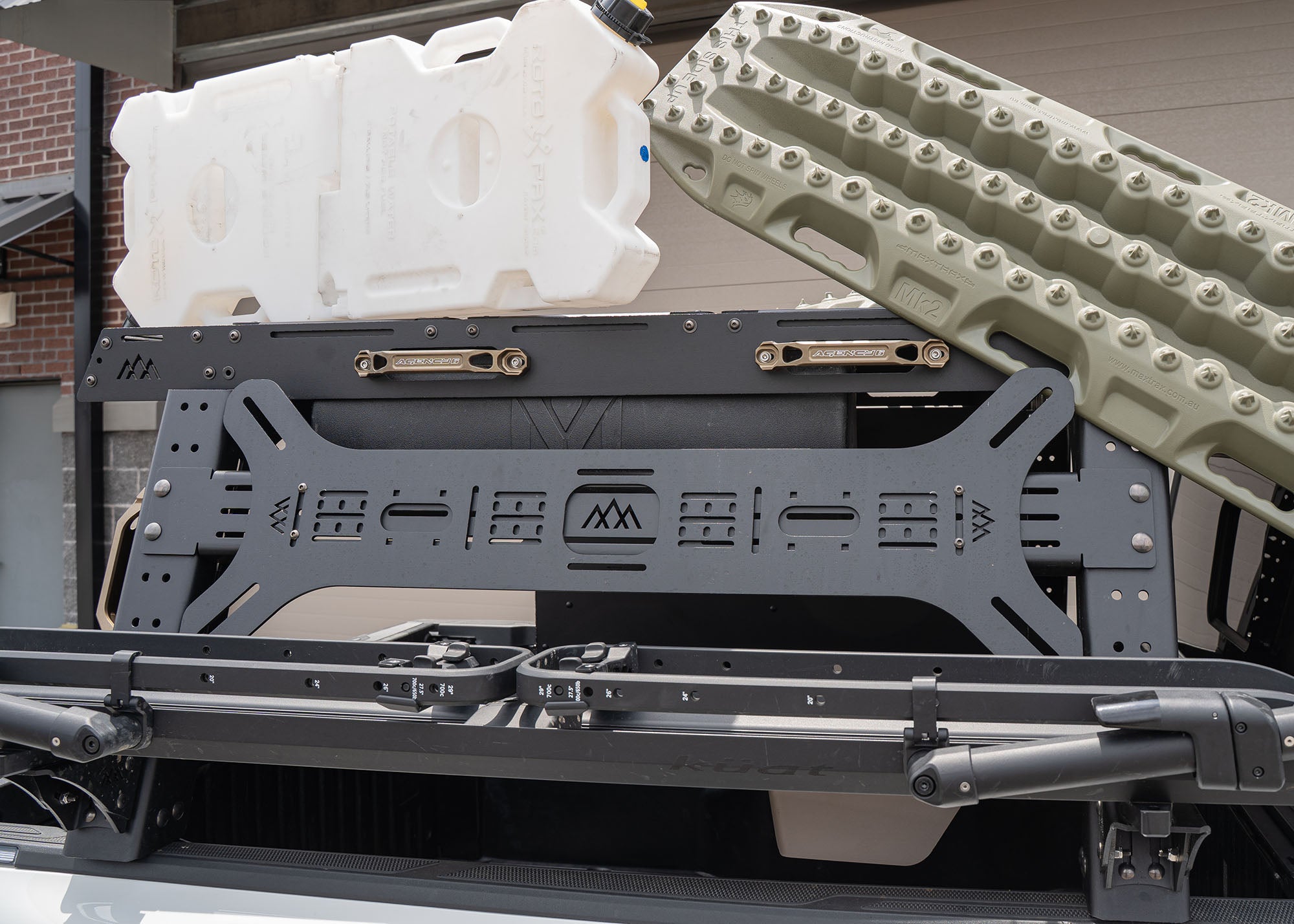 Dogbone Universal Traction Off Road Recovery Traction Board Mount installed on a Backwoods Adventure Mods truck bed rack