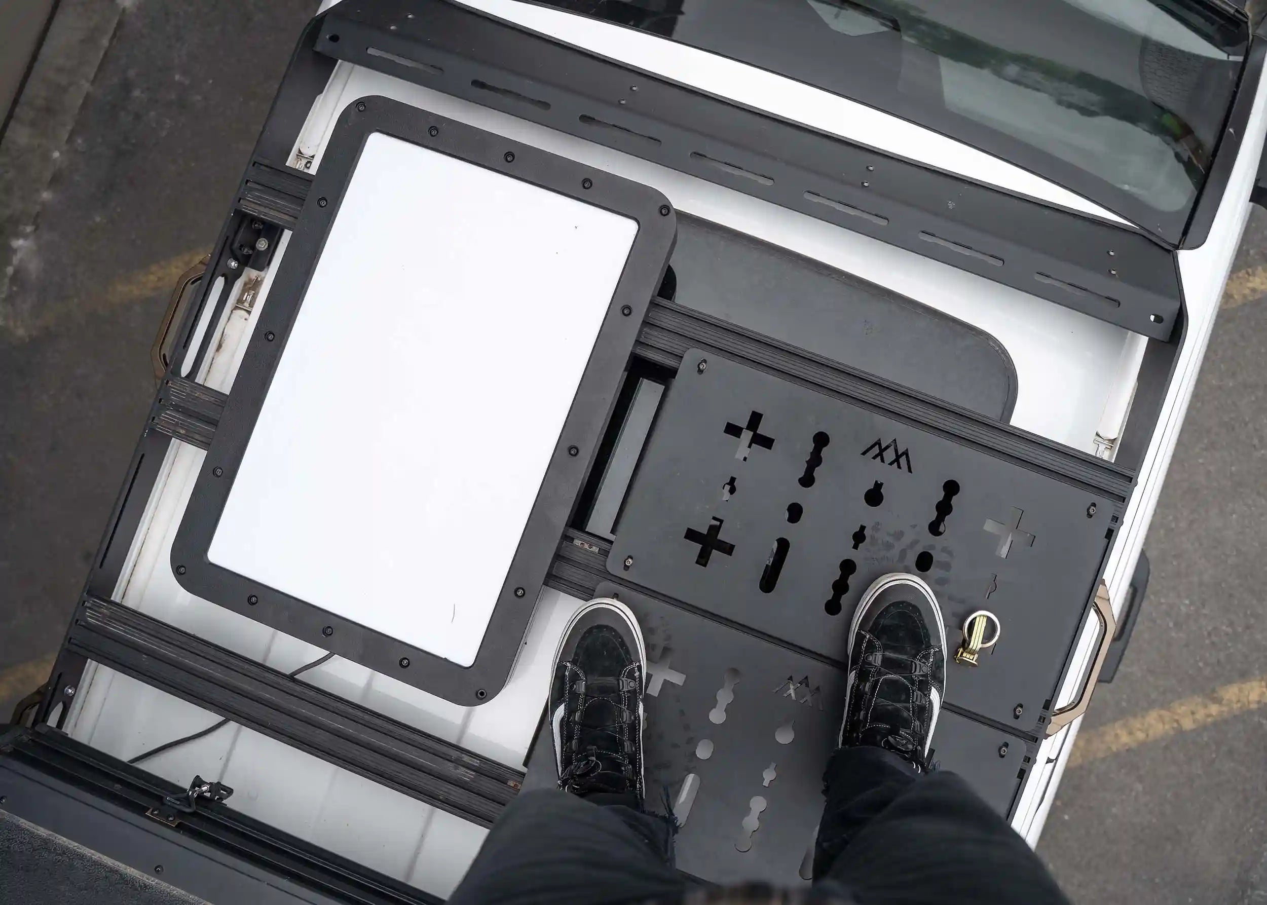 Man standing on top of the DRIFTR 2024+ 4th Gen Toyota Tacoma Roof Rack with optional deck panels installed