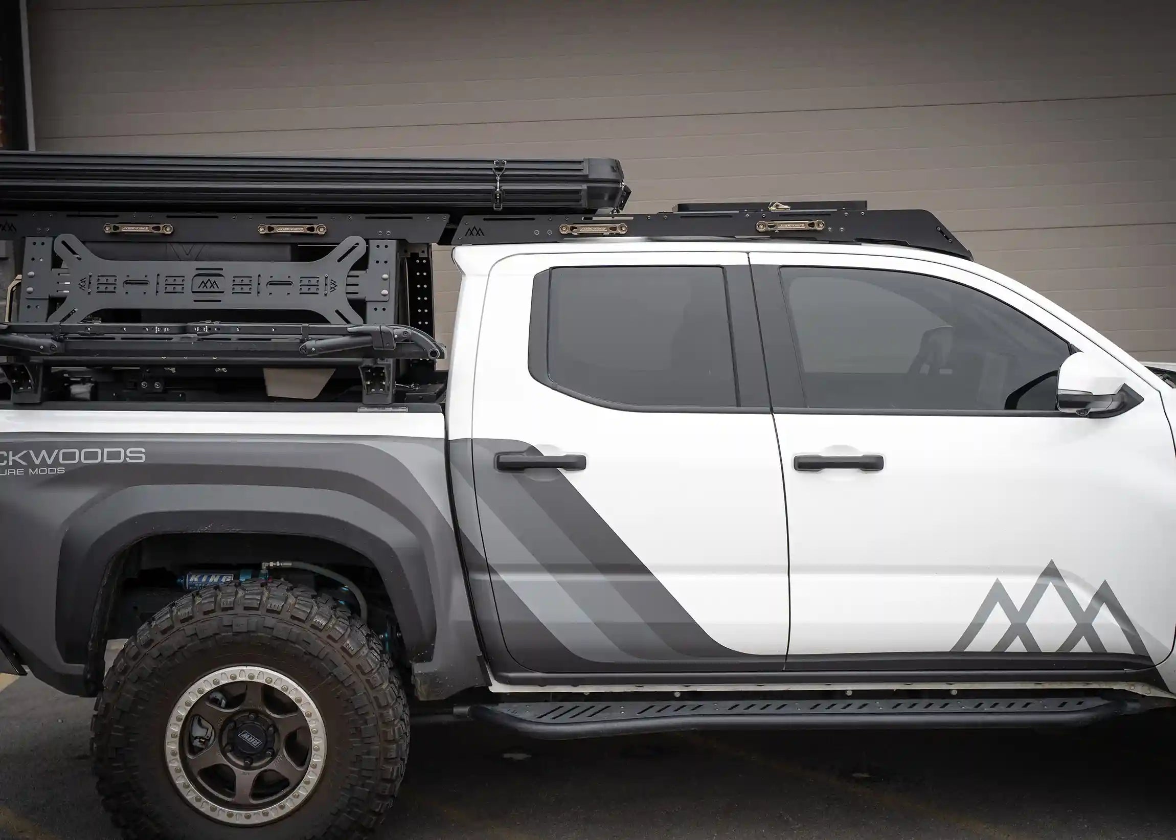 Image showing the DRIFTR 2024 4th gen Toyota Tacoma Roof Rack installed with a Backwoods Adventure Mods tacoma bed rack