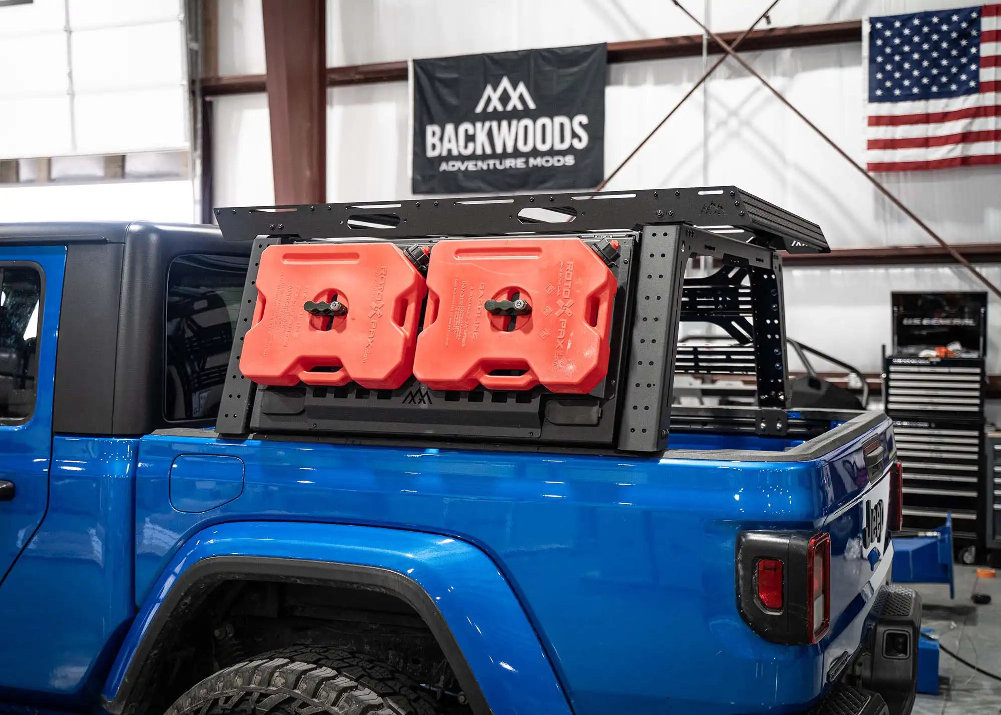 Blue Jeep Gladiator with Backwoods Adventure Mods Jeep Gladiator Bed Rack Storage Box installed along with other bed rack accessories