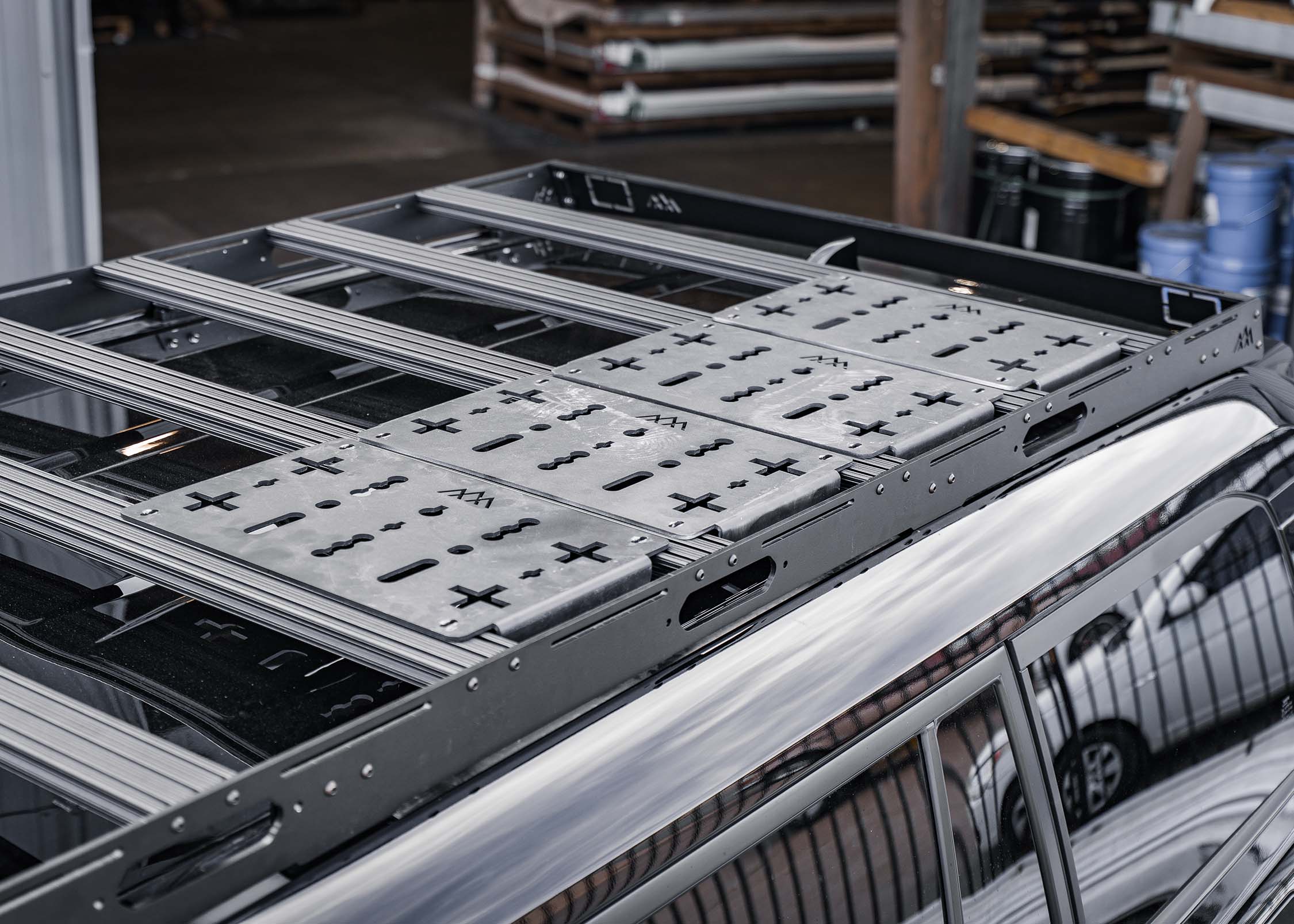 Backwoods Adventure Mods Toyota Land Cruiser 250 DRIFTR roof rack with modular deck plate accessories installed on the t-track load bars