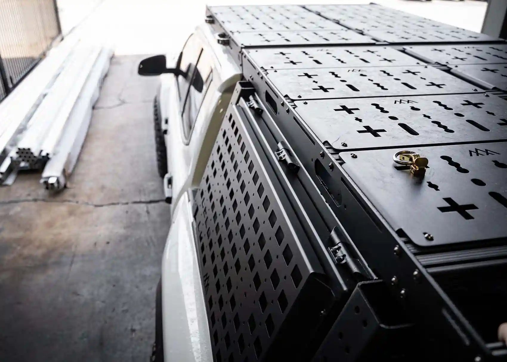 Close-up image of the heavy-duty hinges on the lid of the Backwoods Adventure Mods Toyota Tacoma bed rack storage box