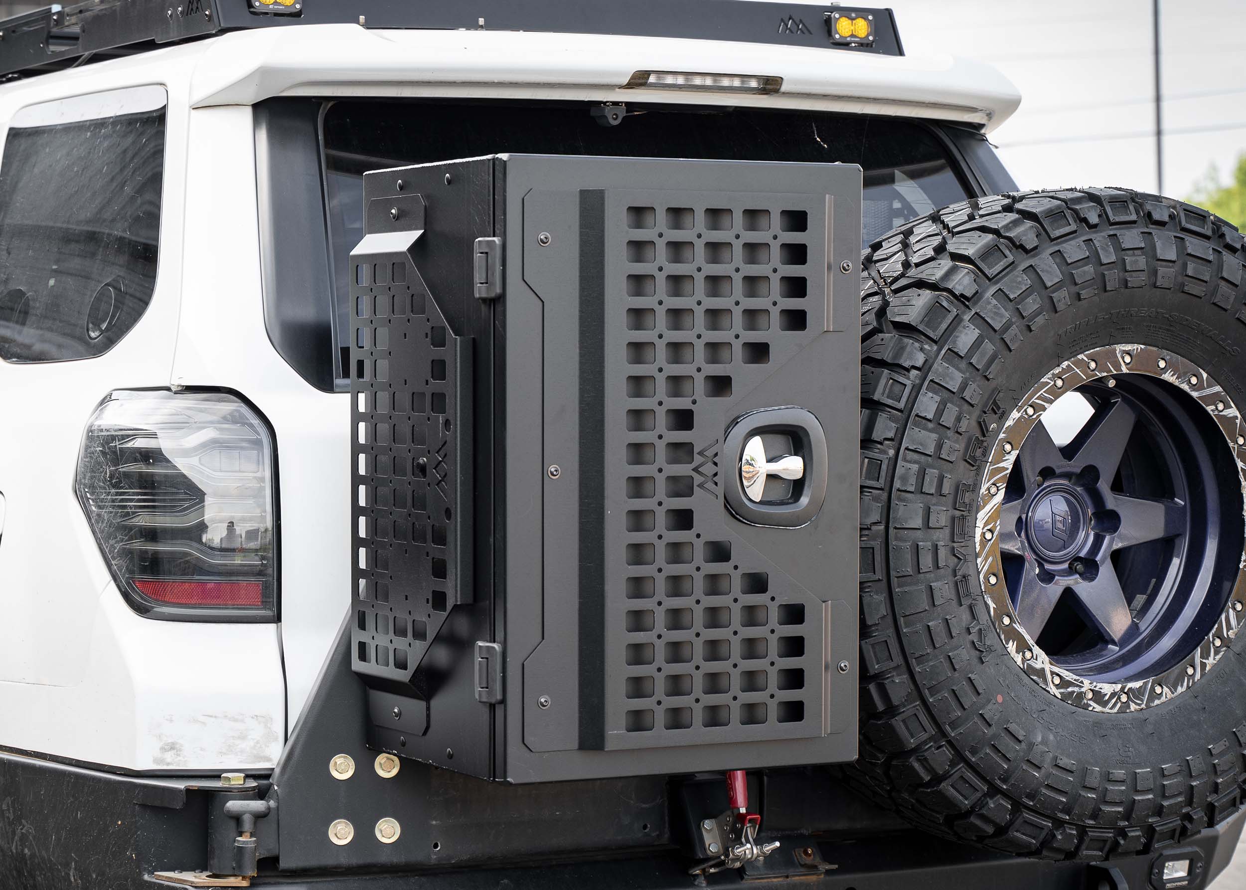 Backwoods Adventure Mods Universal off-road overland vehicle gear storage cargo box attached to a white 4runner swingout bumper