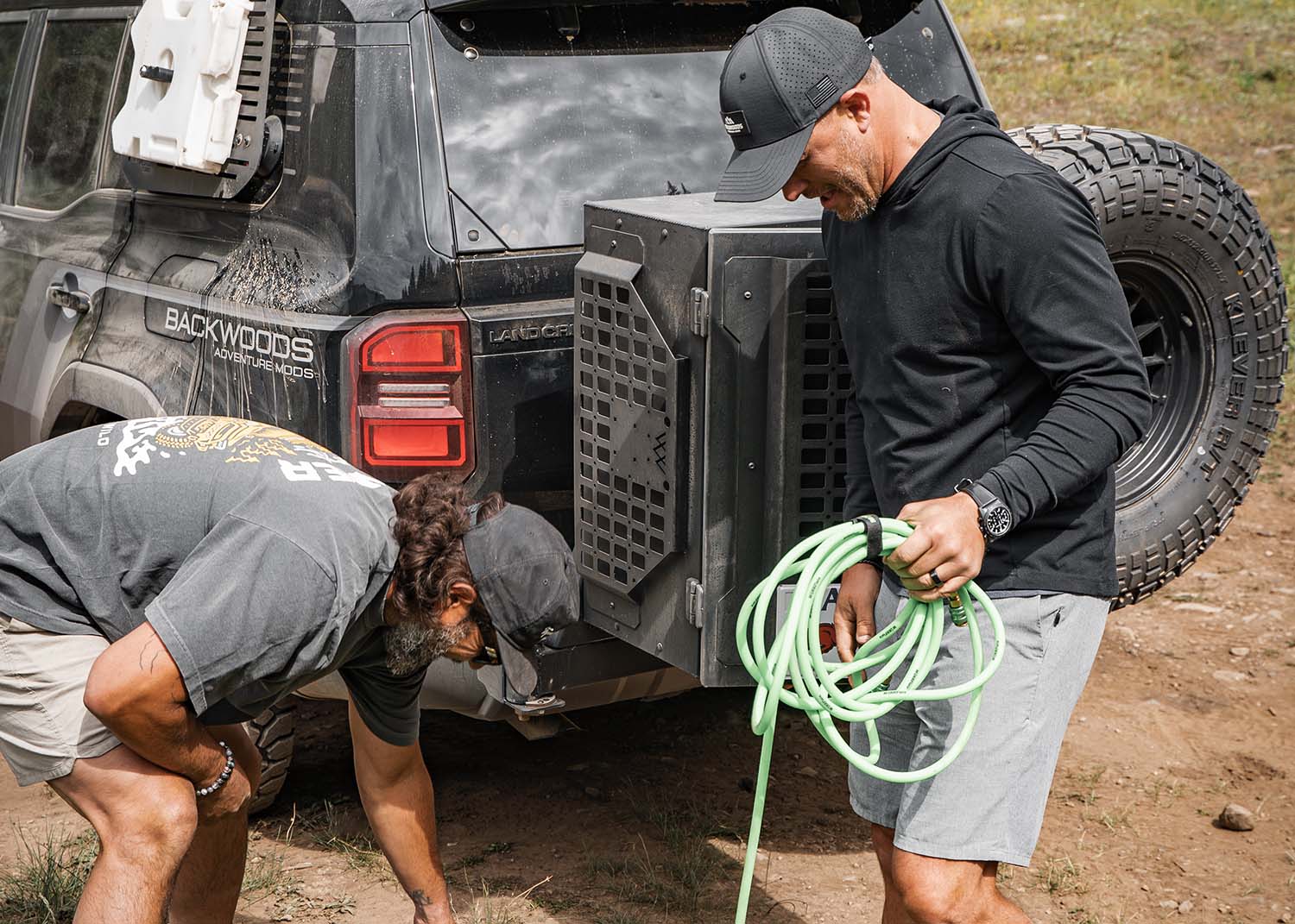 Men removing off road gear from the Backwoods Adventure Mods Universal off-road vehicle overland storage cargo box mounted on a Landcruiser 250