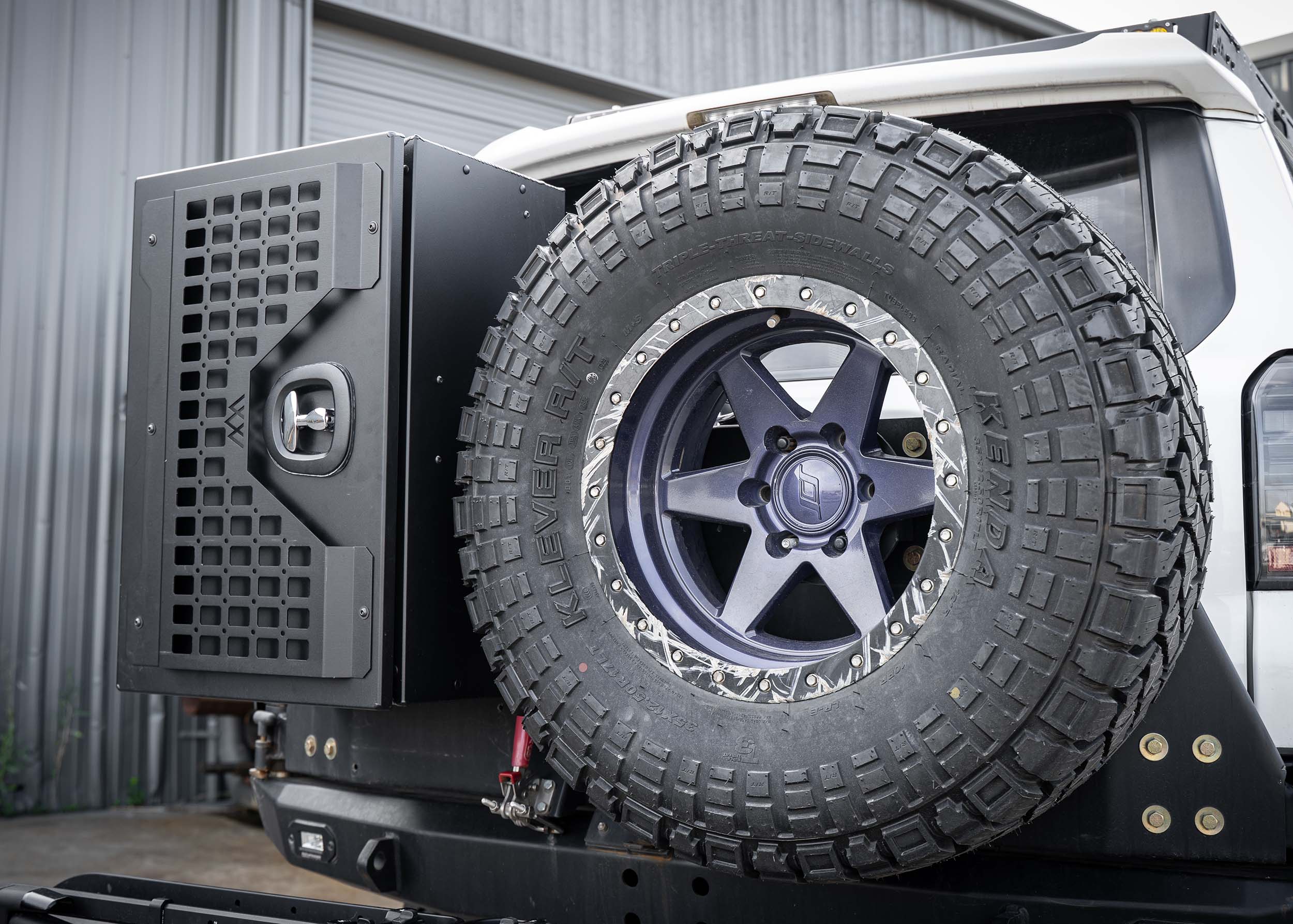 Side profile of the Backwoods Adventure Mods Universal overland gear storage cargo box mounted on an off-road vehicle swing out bumper