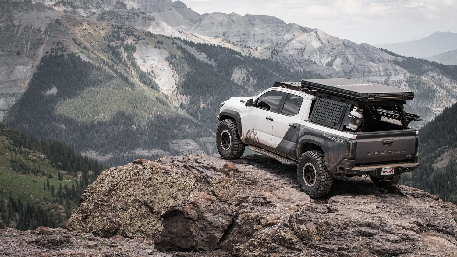 White 4th Gen Toyota Tacoma equipped with 4th Gen Tacom mods - including bumpers, rock sliders, roof rack, bed rack, rooftop tent, awning, and other overland accessories - from Backwoods Adventure Mods