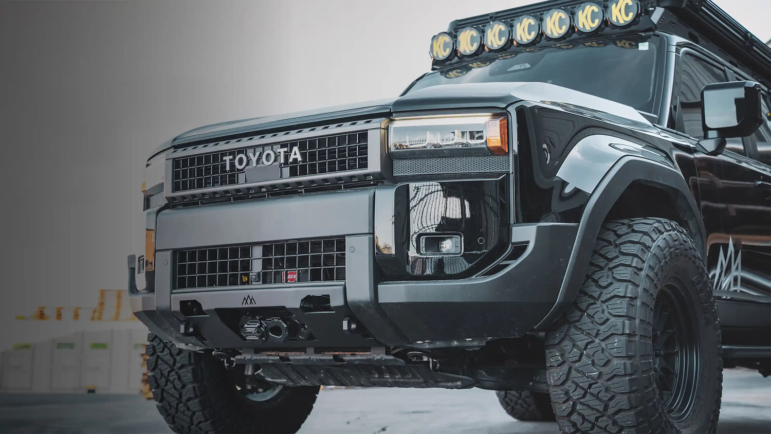 Close up of LC250 Mods and Accessories - including winch bumper, roof rack, rooftop tent, rock sliders, and other overland accessories - from Backwoods Adventure Mods installed on a  black Toyota Land Cruiser 250