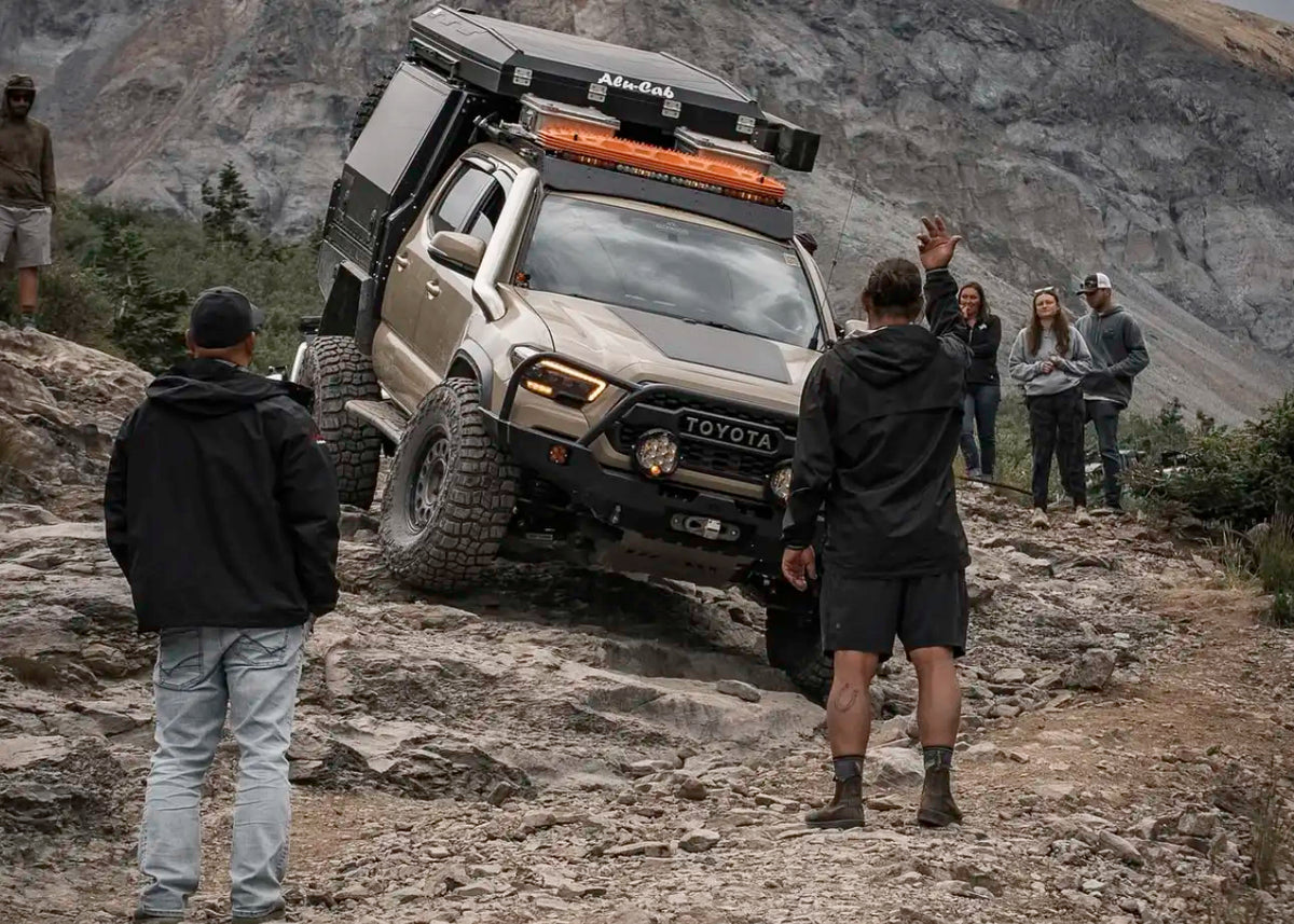 Tacoma skid plates protecting a 3rd gen Tacoma undercarriage while driving over rocky terrain on a mountain pass