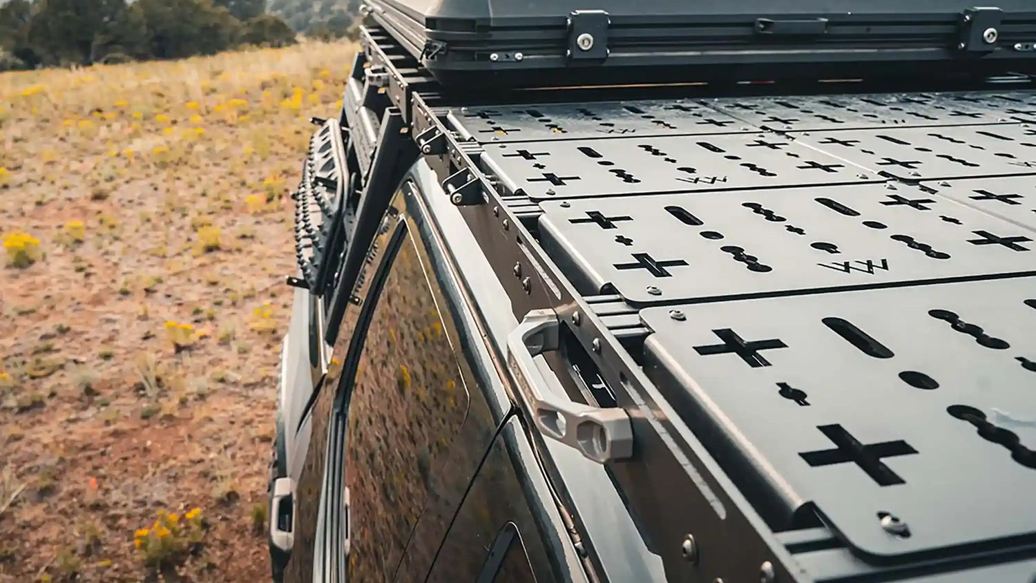 Close-up of Toyota roof rack system from Backwoods Adventure Mods installed on a overland truck build with roof rack accessories and a rooftop tent installed