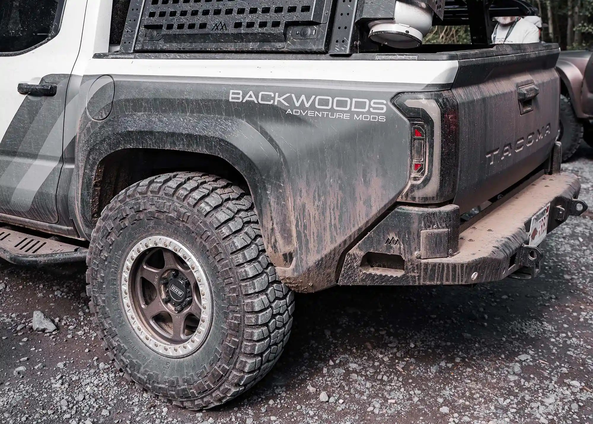 2024 Toyota Tacoma Rear Bumper by Backwoods Adventure Mods installed on a 4th gen Tacoma driving off road covered in mud