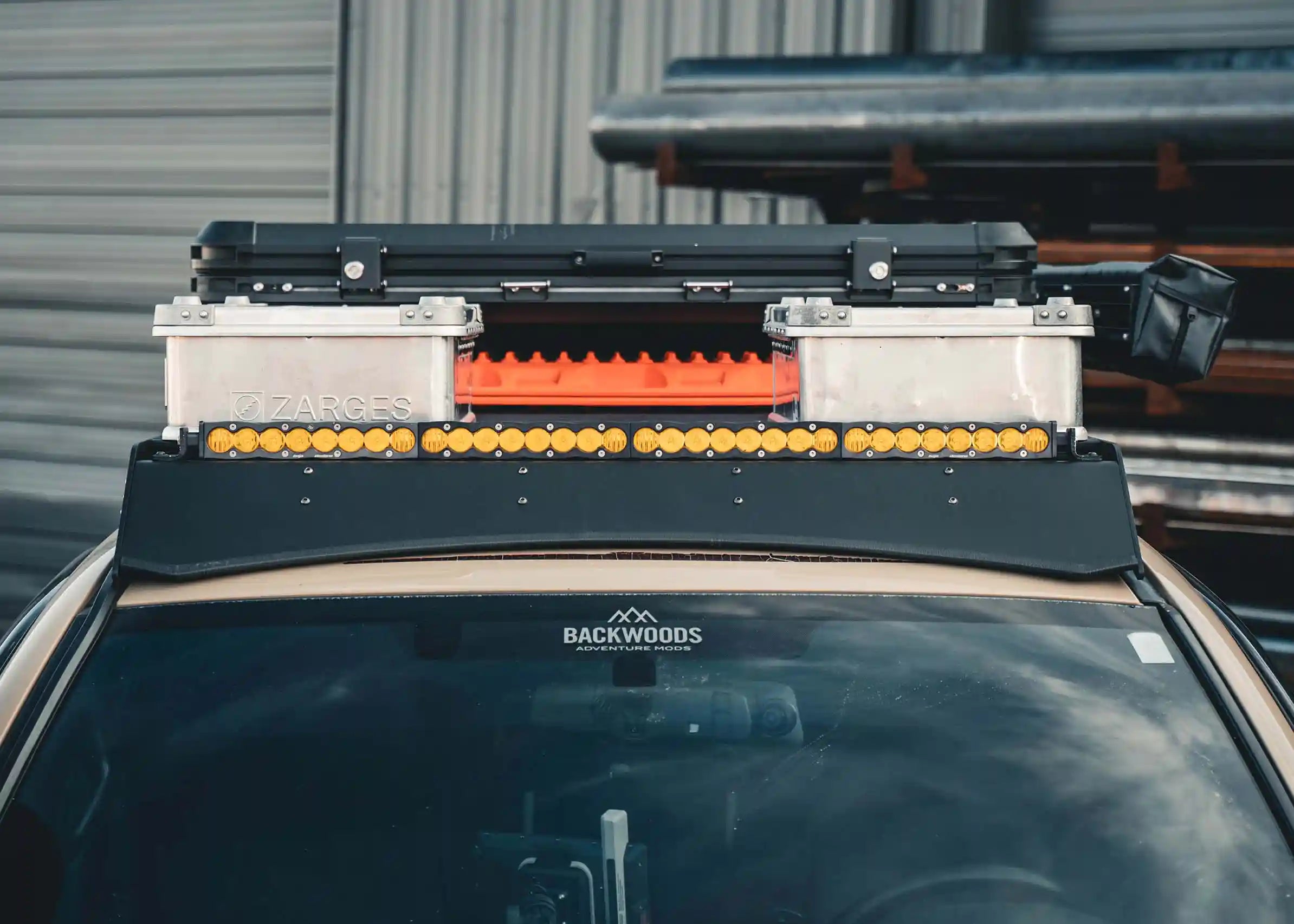 Image showing the front of the Backwoods Adventure Mods 2005-2023 2nd and 3rd Gen Toyota Tacoma DRIFTR Roof Rack with gear mounted and off road lights installed