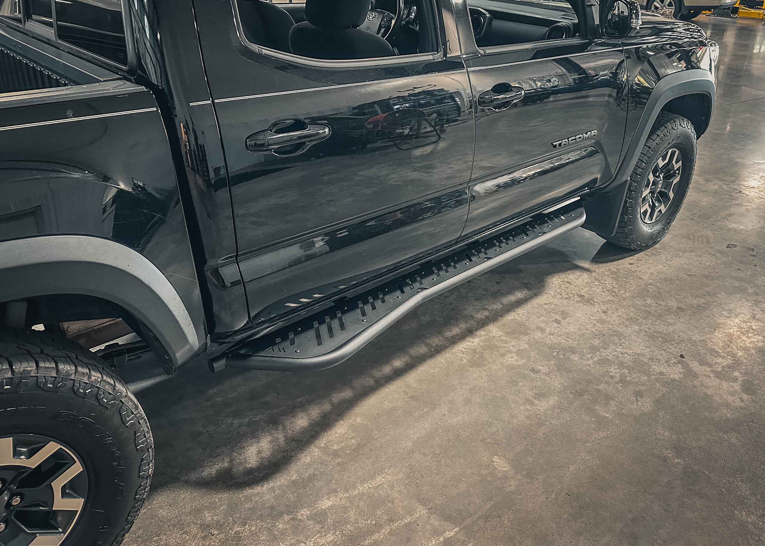 Backwoods Adventure Mods 2005-2023 Toyota Tacoma Rock Sliders installed on a black 3rd Gen Tacoma 