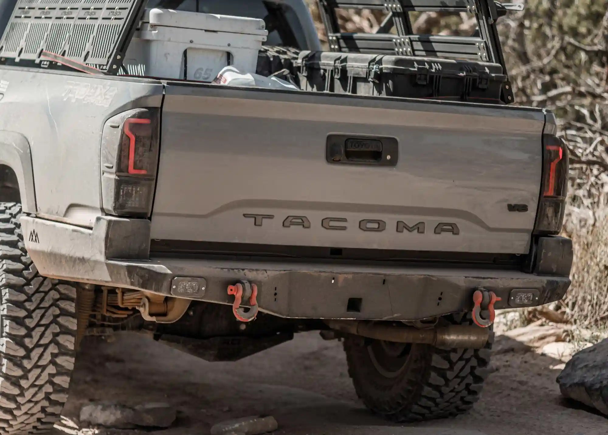Backwoods Adventure Mods Toyota Tacoma (2016-2023) Hi-Lite High Clearance Rear Bumper installed on a gray 3rd Gen Tacoma being driven off road