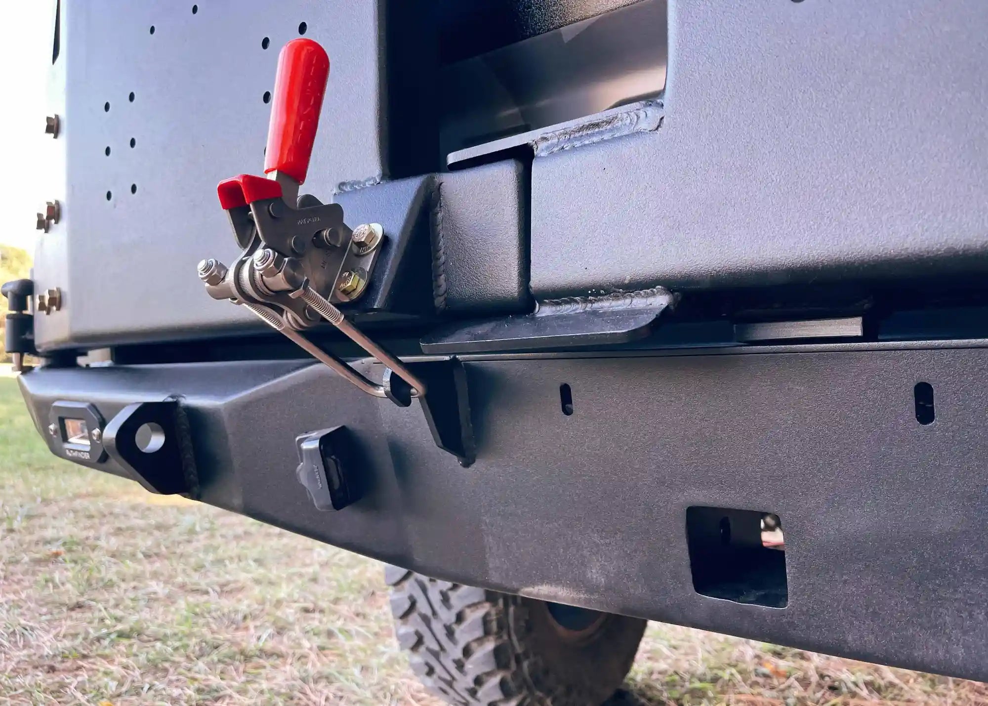 Close up of the swing out latch on the Backwoods Adventure Mods 2016-2023 3rd Gen Toyota Tacoma Hi-Lite High Clearance Dual Swing Out Rear Bumper 