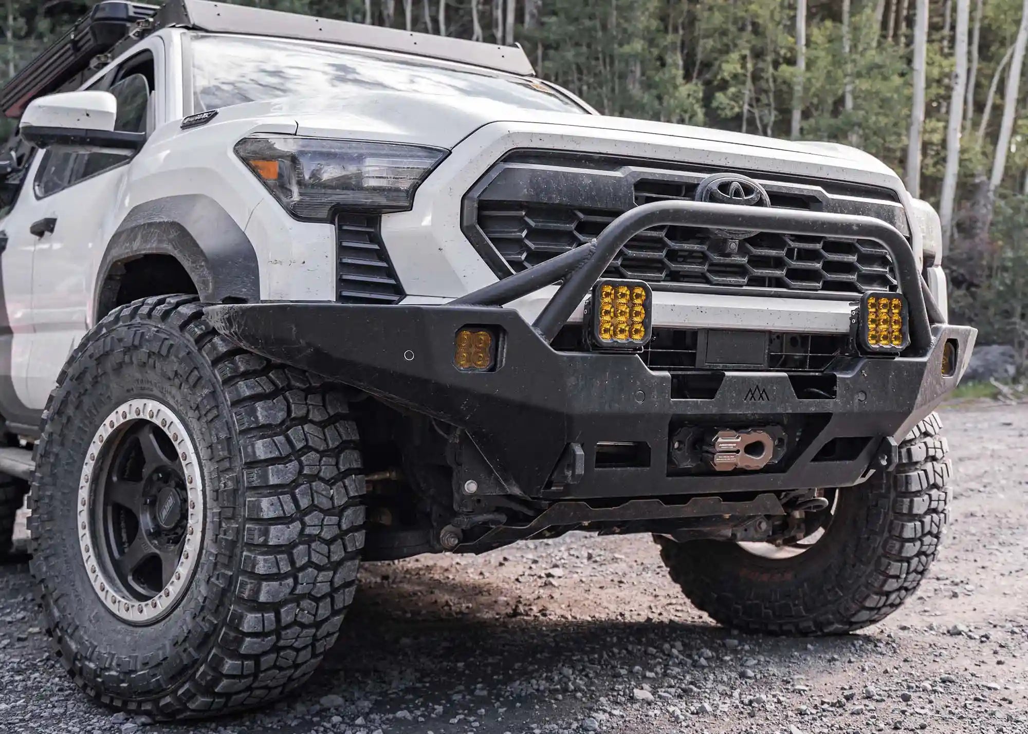 White 2024 4th Gen Toyota Tacoma with Backwoods Adventure Mods Hi-Lite Overland high clearance Front Bumper with Prerunner Bull Bar and winch installed