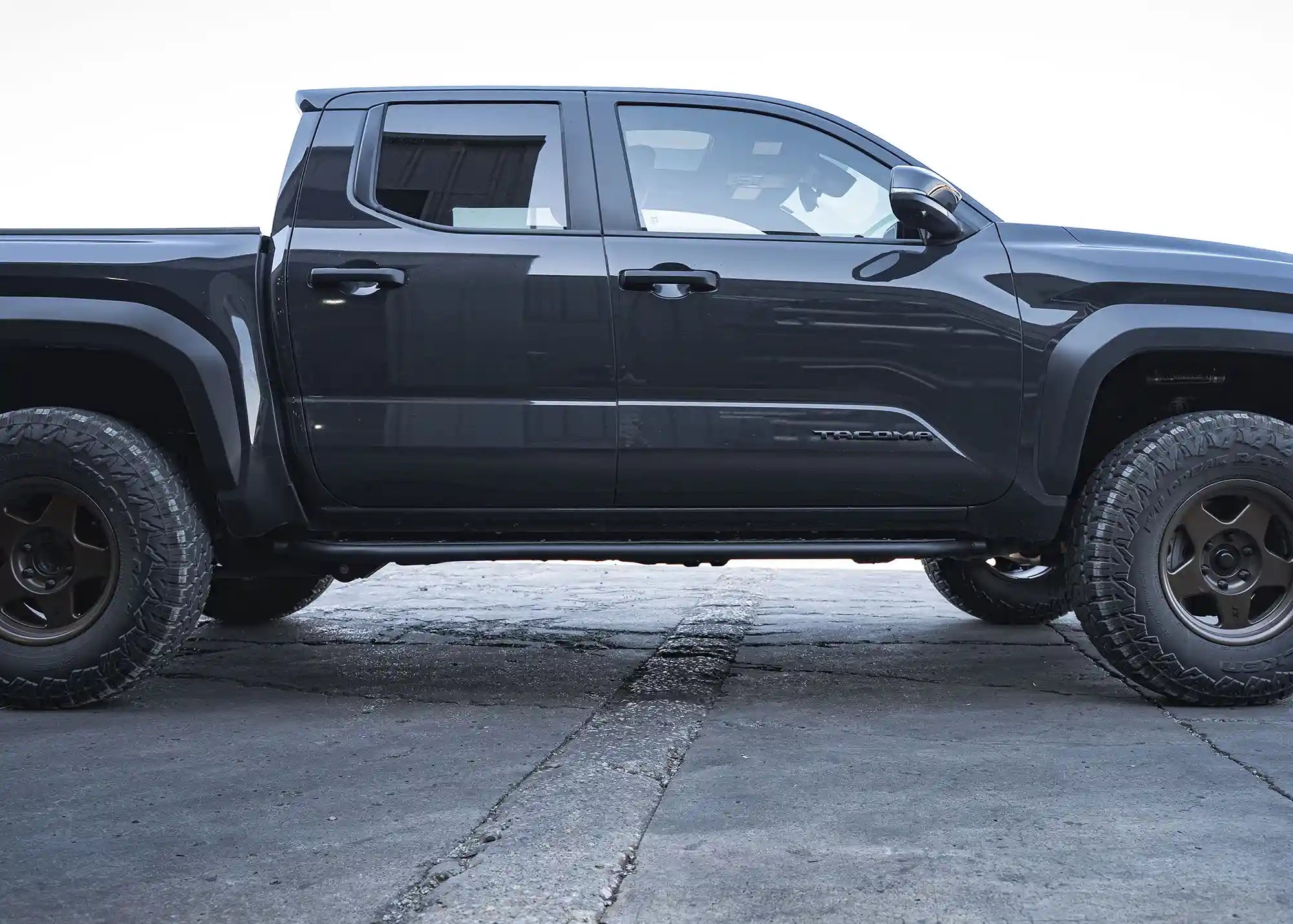Side profile of the 2024-2026 Toyota Tacoma Rock Sliders with Side Steps from Backwoods Adventure Mods installed on a 4th Gen Tacoma
