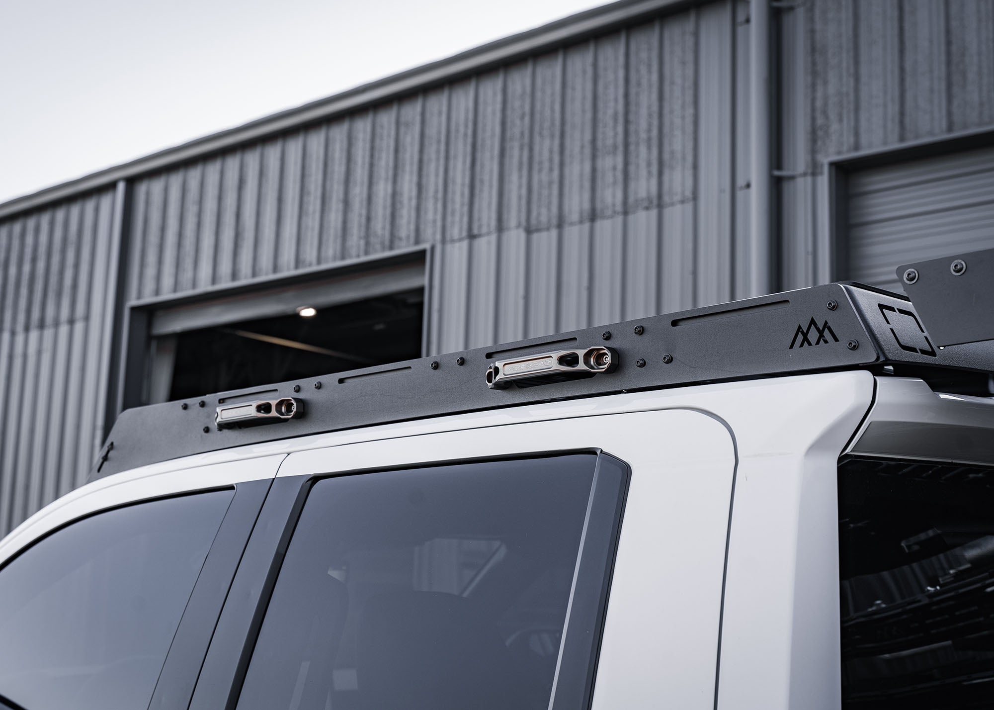 Backwoods Adventure Mods DRIFTR roof rack cargo carrier installed on a white 2024 4th gen Toyota Tacoma