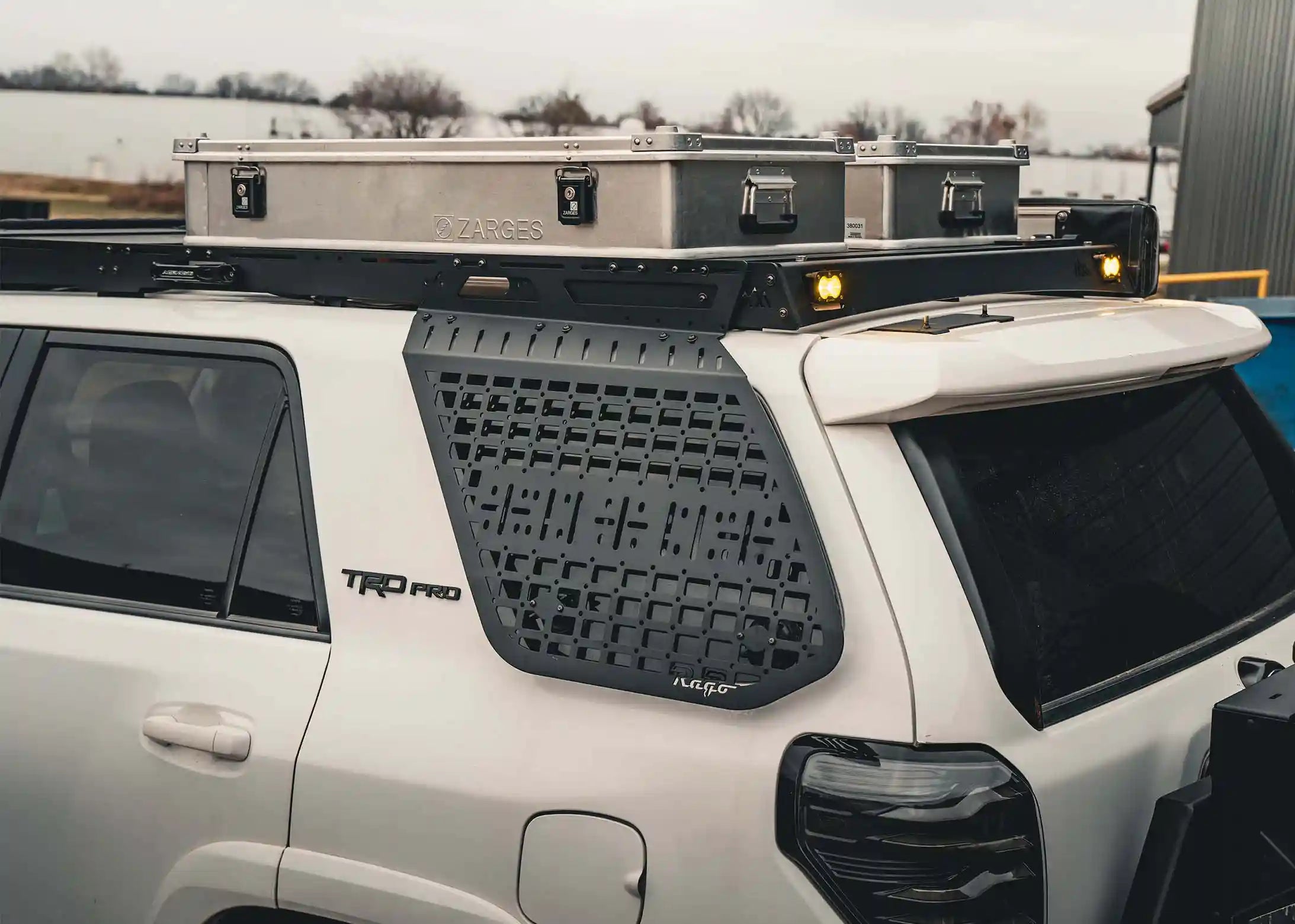 Cargo storage boxes mounted to the built-in T-track load bars in the Backwoods Adventure Mods Toyota 2010-2024 5th Gen 4Runner DRIFTR Roof Rack 