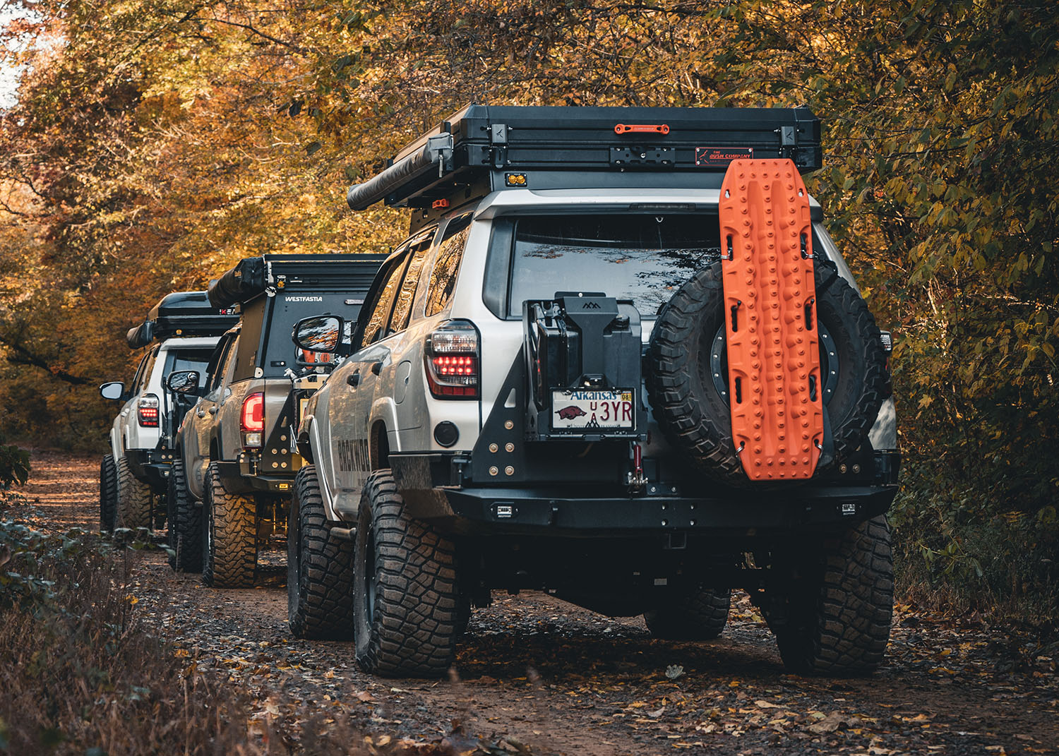Line of Overland Toyotas driving off road with a 5th Gen Toyota 4Runner with a Backwoods Adventure Mods Hi-Lite High Clearance Dual Swing Out Rear Bumper installed in the back