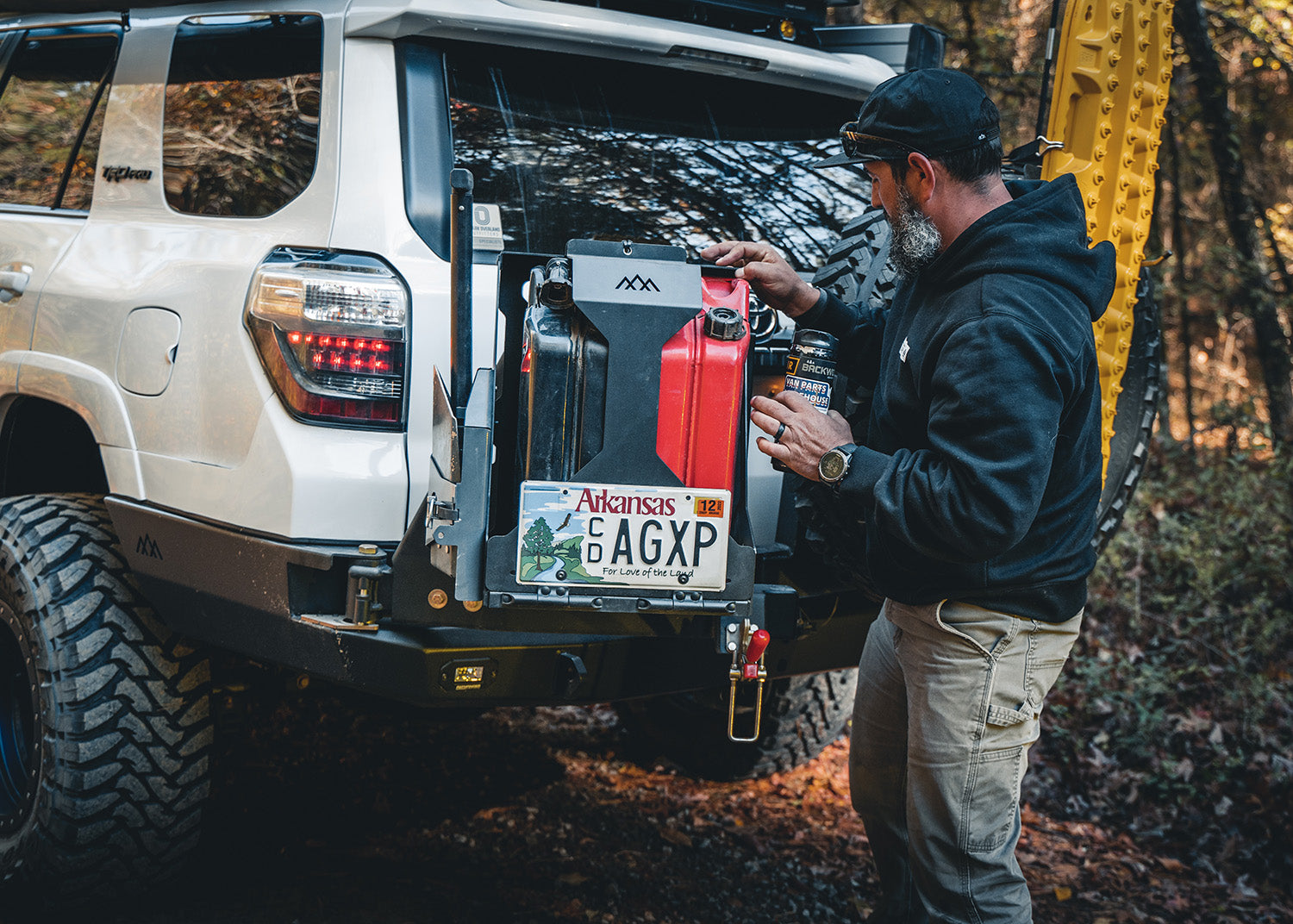 Man using the dual swing out on the Backwoods Adventure Mods 5th Gen Toyota 4Runner Hi-Lite High Clearance Rear Bumper