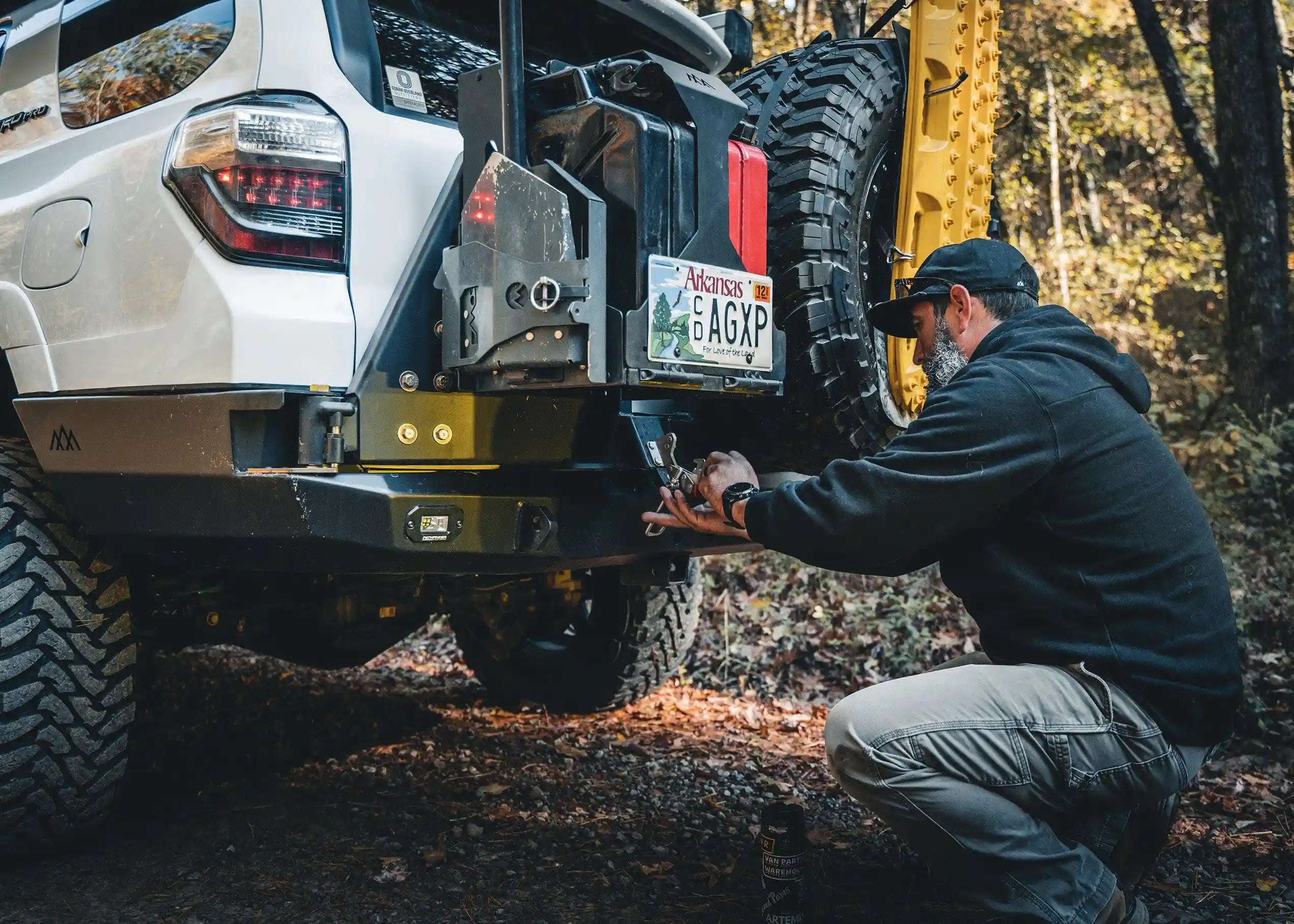 Man securing the latch on the 5th Gen Toyota 4Runner Hi-Lite High Clearance Dual Swing Out Rear Bumper by Backwoods Adventure Mods