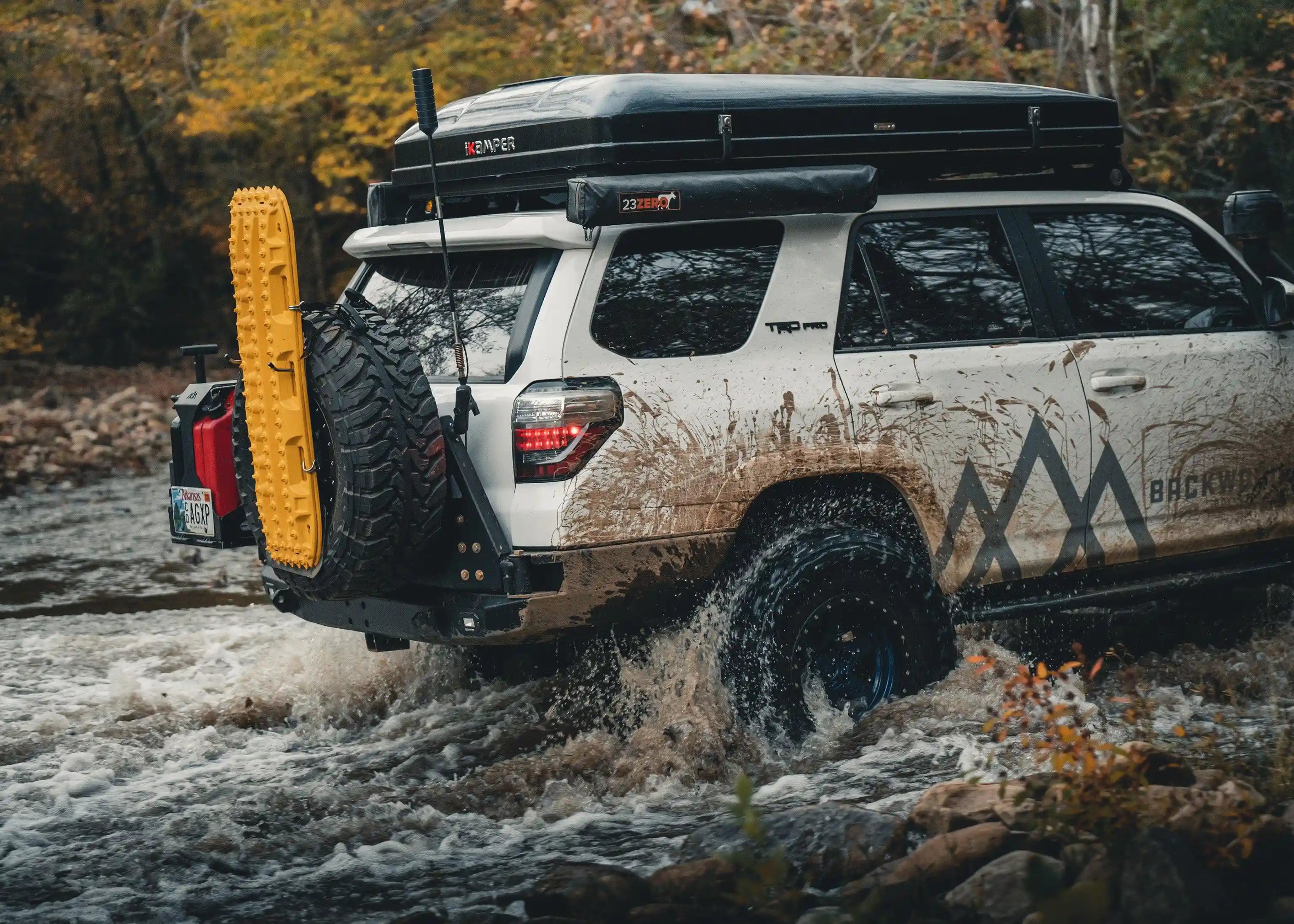 5th Gen Toyota 4Runner (2014-2022) driving off road through water with a Backwoods Adventure Mods Hi-Lite High Clearance Dual Swing Out Rear Bumper installed