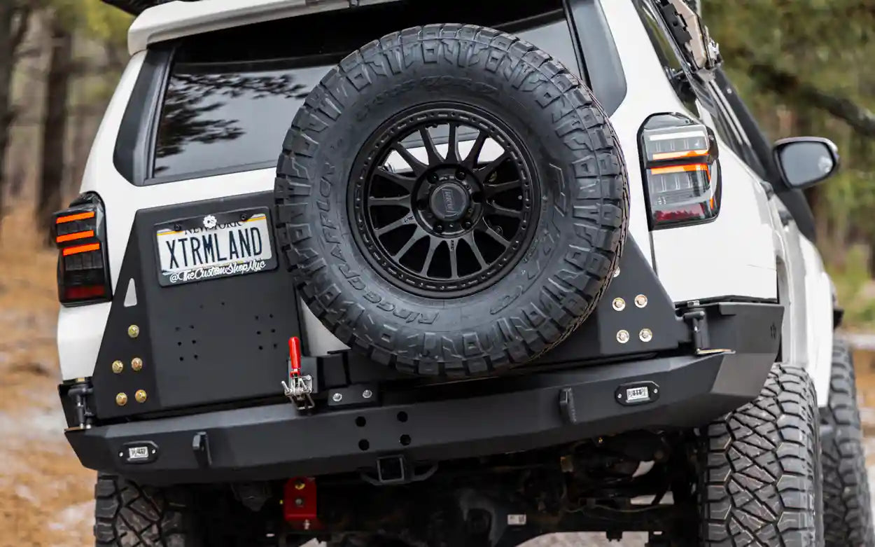 Close up of a spare tire mounted on the Backwoods Adventure Mods Hi-Lite 5th Gen Toyota 4Runner High Clearance Dual Swing Out Rear Bumper