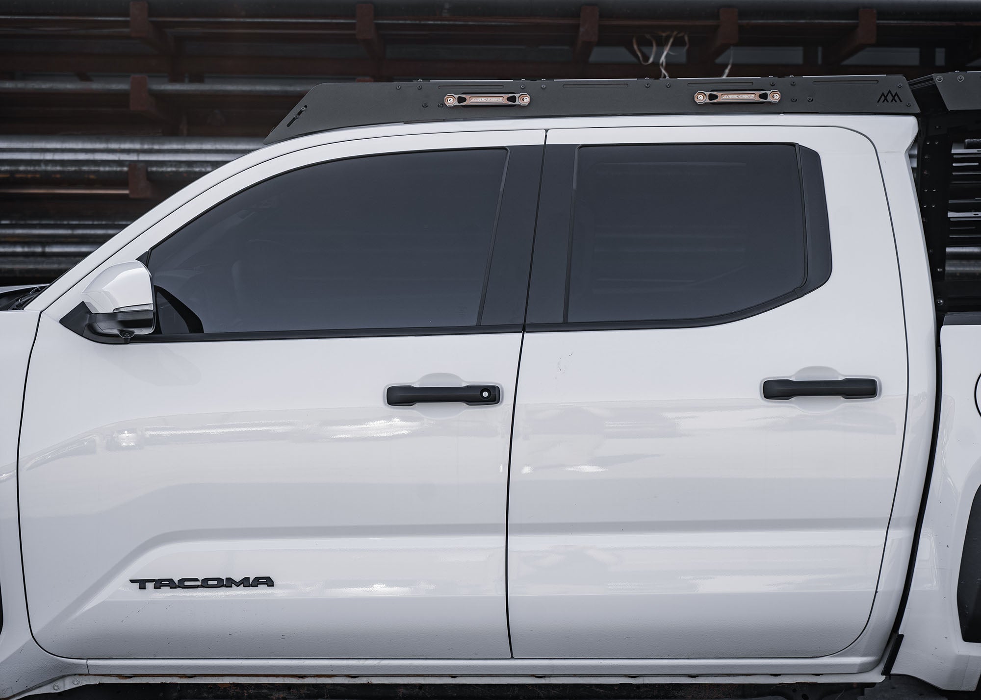 side view of a Backwoods Adventure Mods DRIFTR roof rack installed on a white 2024 4th gen Toyota Tacoma