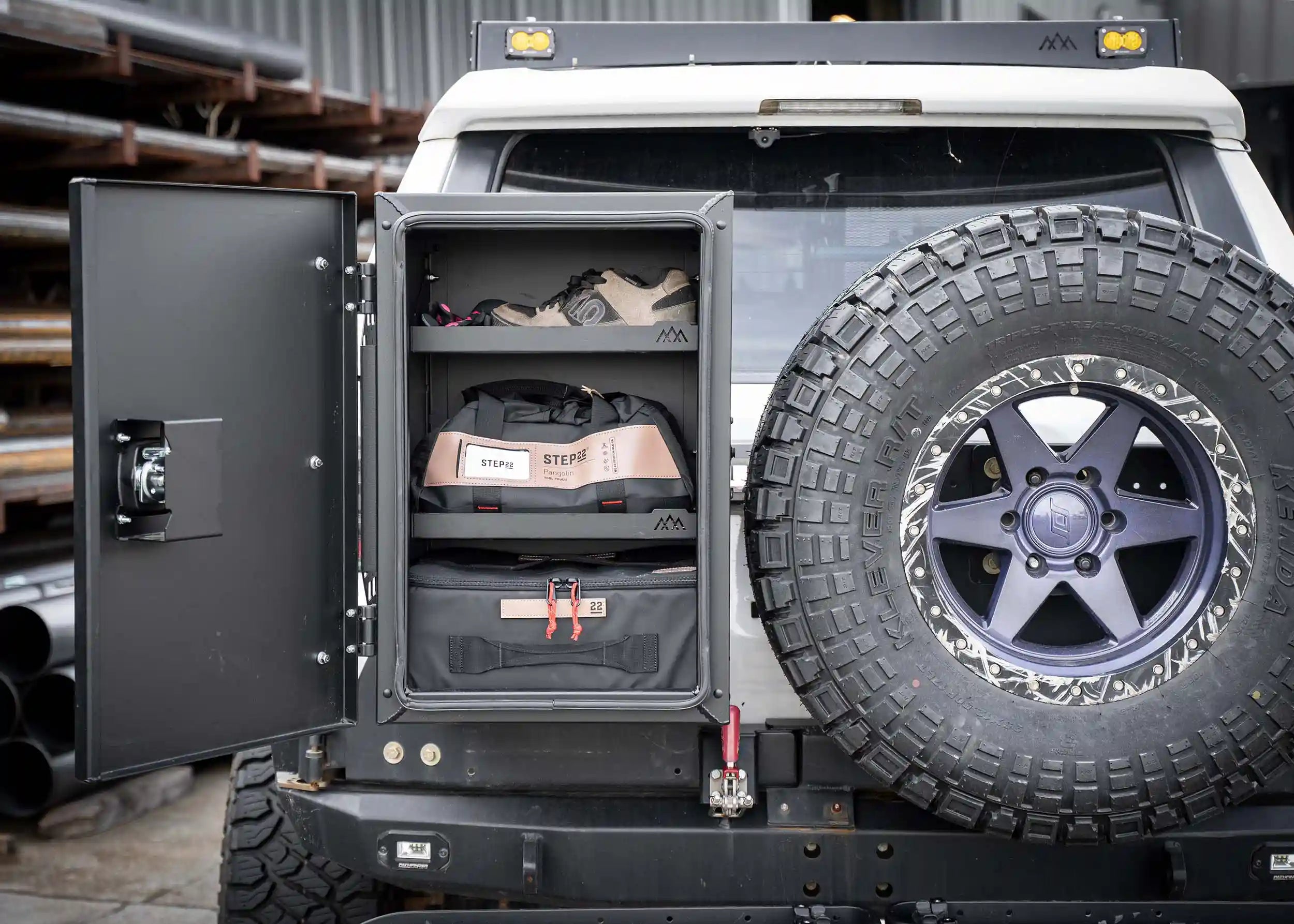 Toyota 4runner equipped with Backwoods Adventure Mods roof rack, rear swing out bumper, tire carrier, and overland storage box full of off road accessories.