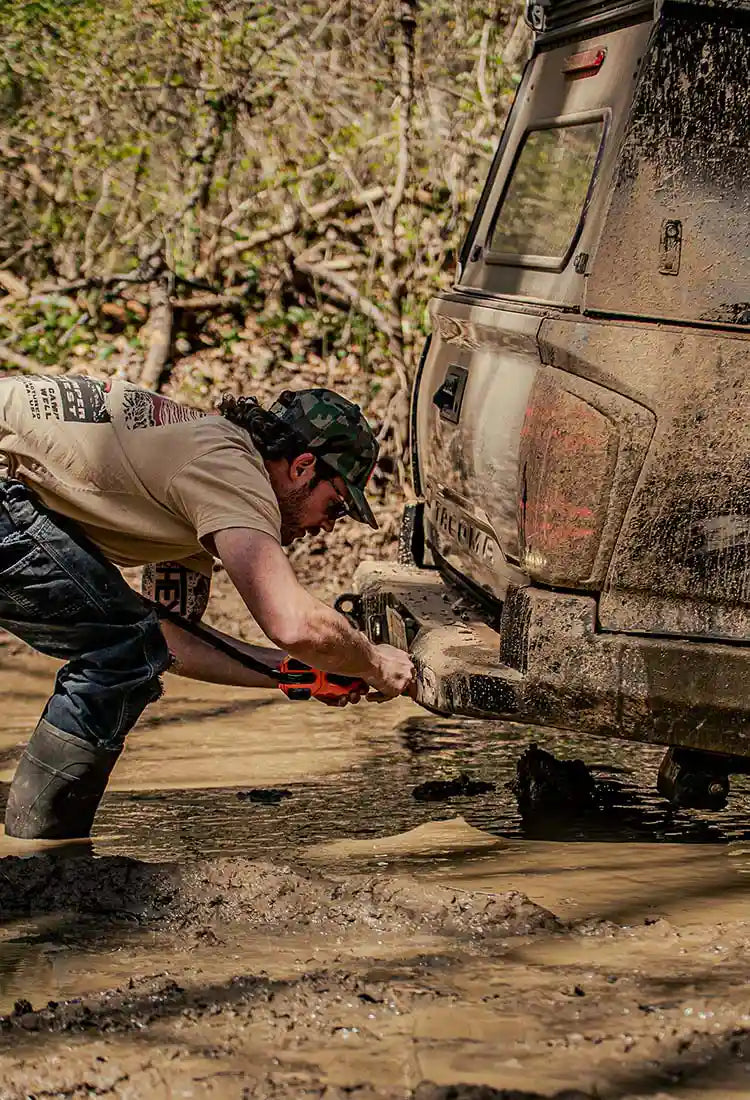Grant with Backwoods Adventure Mods hooking a winch cable to the rear of a Toyota Tacoma equipped with a Backwods Adventure Mods Rear Bumper