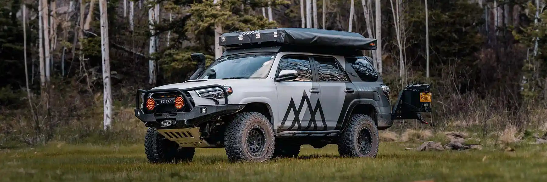 Toyota 4Runner equipped with Backwoods Adventure Mods Off Road Accessories parked in a forested field