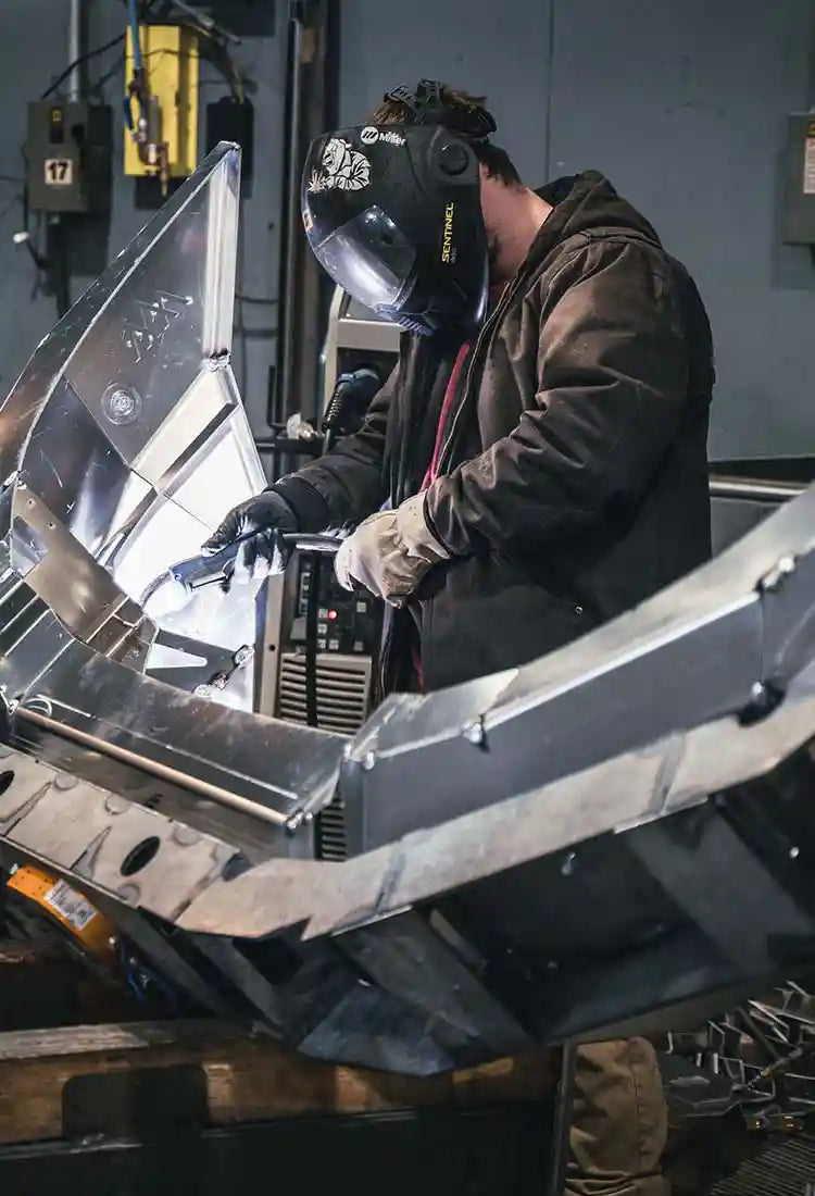 Man welding a Backwoods Adventure Mods Front Bumper