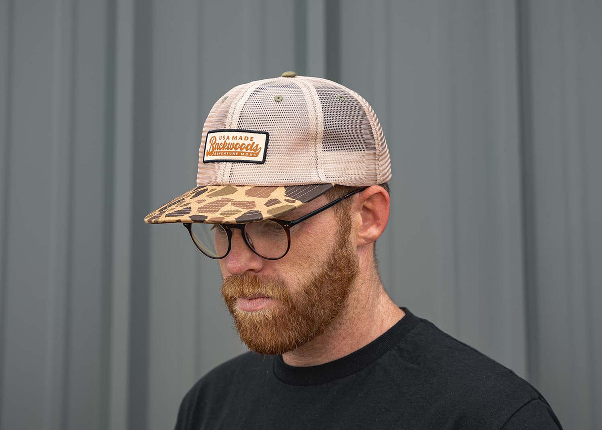 Man wearing camo Backwoods Adventure Mods Trucker Hat