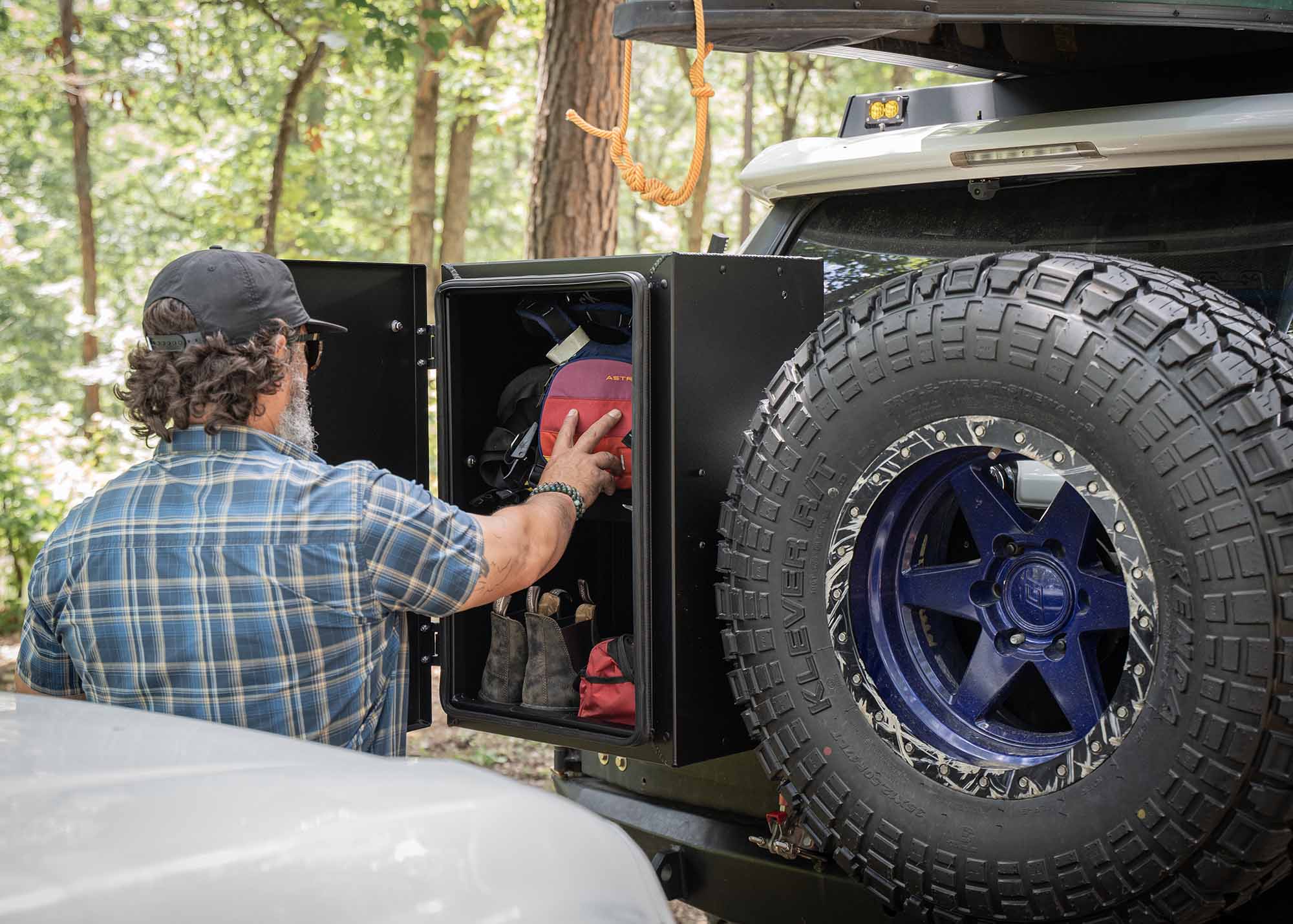 Person accessing hiking gear stored in the Backwoods Adventure Mods Overland Storage Box 