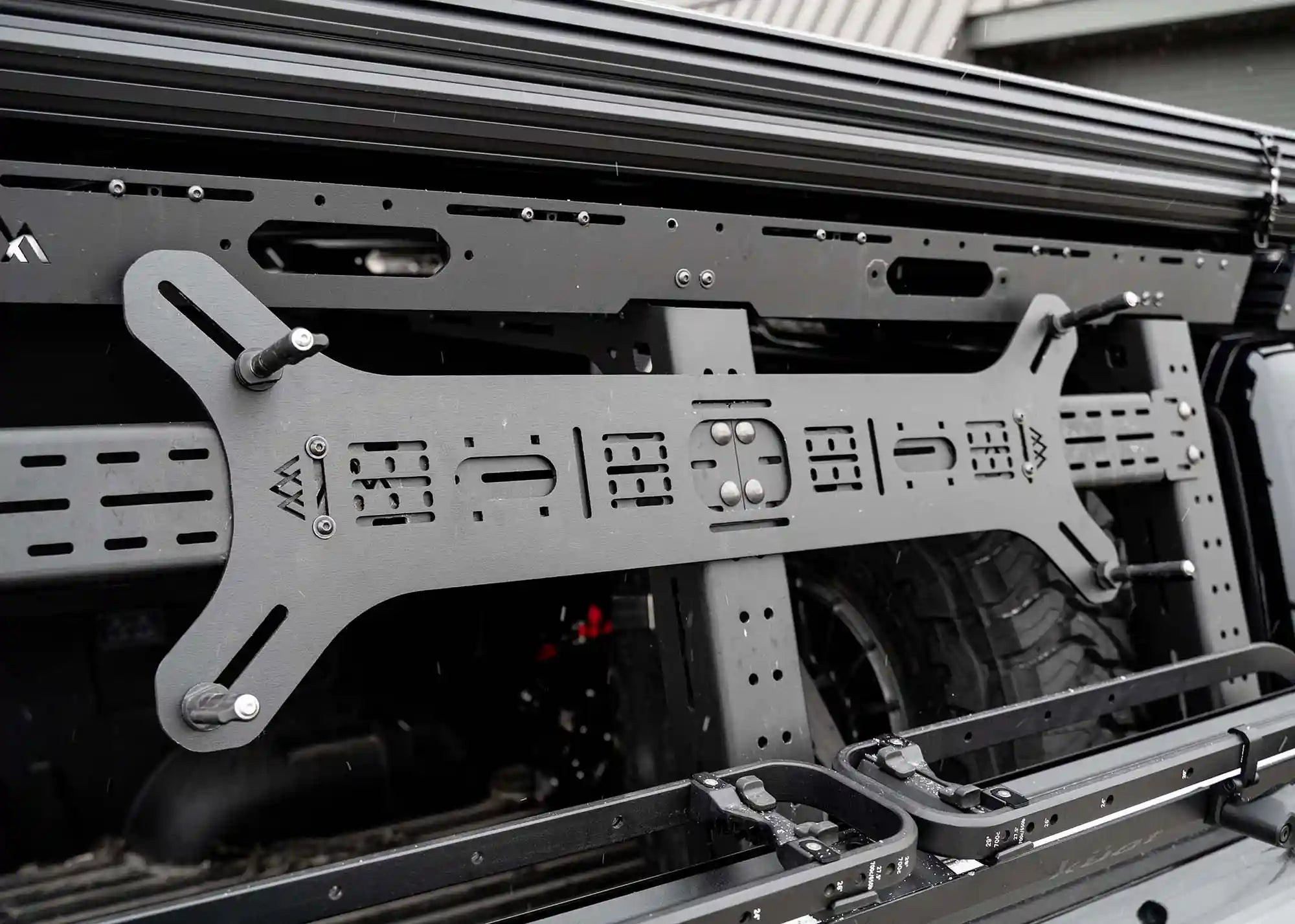 Dogbone Universal Traction Board Mount for off road recovery board storage installed on a modular Backwoods Adventure Mods Overland truck bed rack