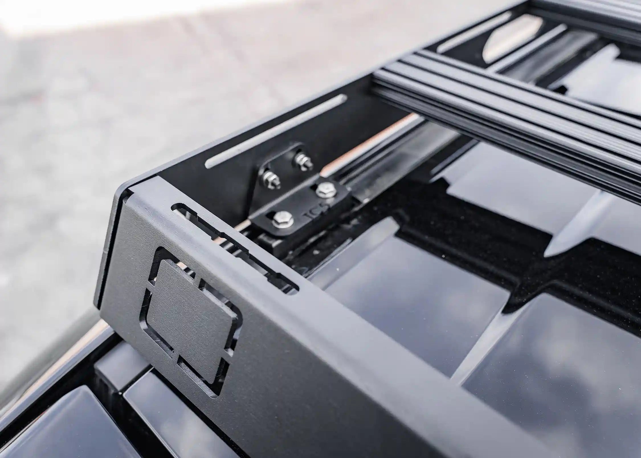 Close up of the mounting bracket and front wind fairing on the Backwoods Adventure Mods DRIFTR LC250 roof rack for the Toyota Land Cruiser 250