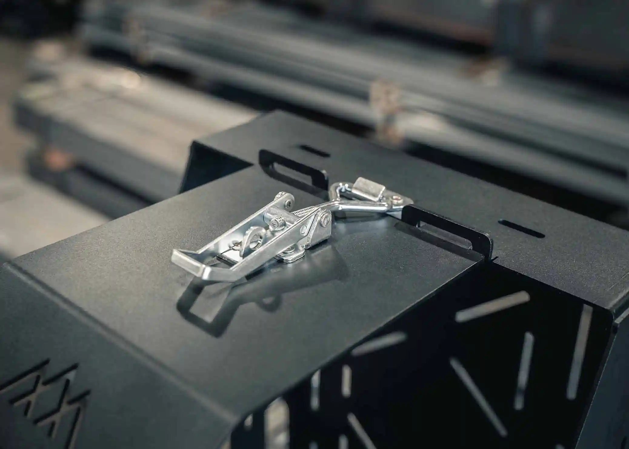 Close up image of the heavy-duty adjustable locking latch on the Jerry's Can Holder - Dual Universal Jerry Can Mount from Backwoods Adventure Mods