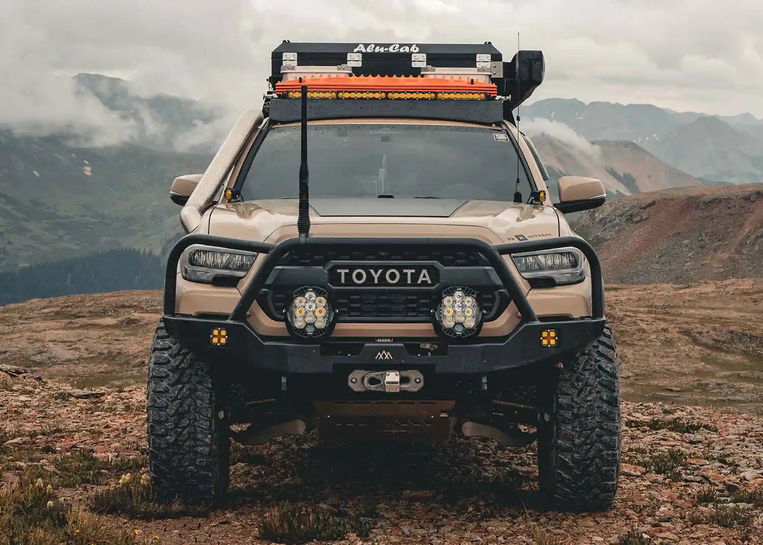3rd Gen Toyota Tacoma Front Bumper with Bull Bar installed on a Tacoma Overland Truck parked on a mountain pass while driving off road