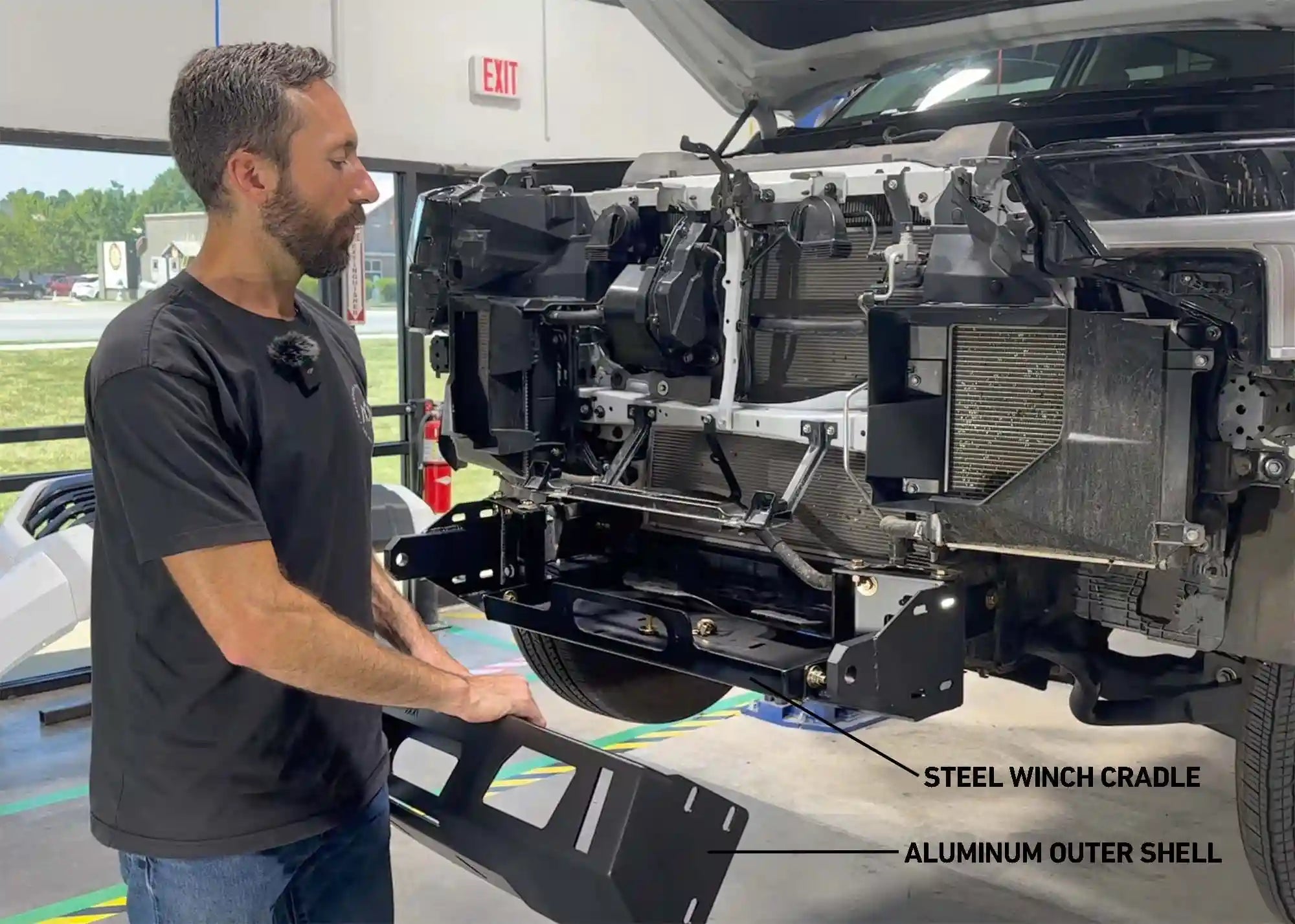 Man installing the Backwoods Adventure Mods Tundra Front Bumper with Warn VR Evo 12s Winch bundle kit on a 3rd Gen Tundra